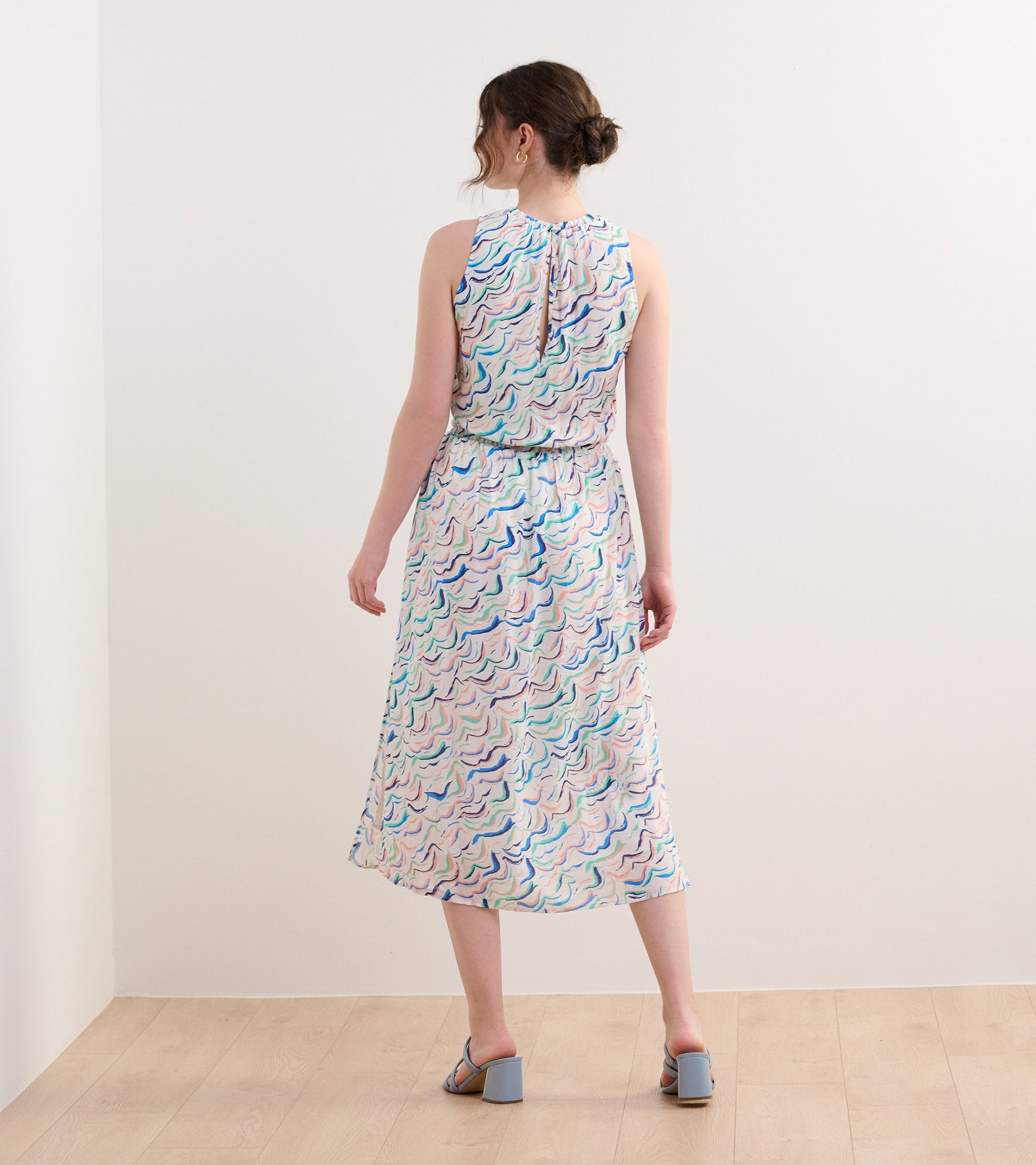 Sleeveless column dress with wavy stripes in pastel colors, featuring a cinched waist and a keyhole back detail.