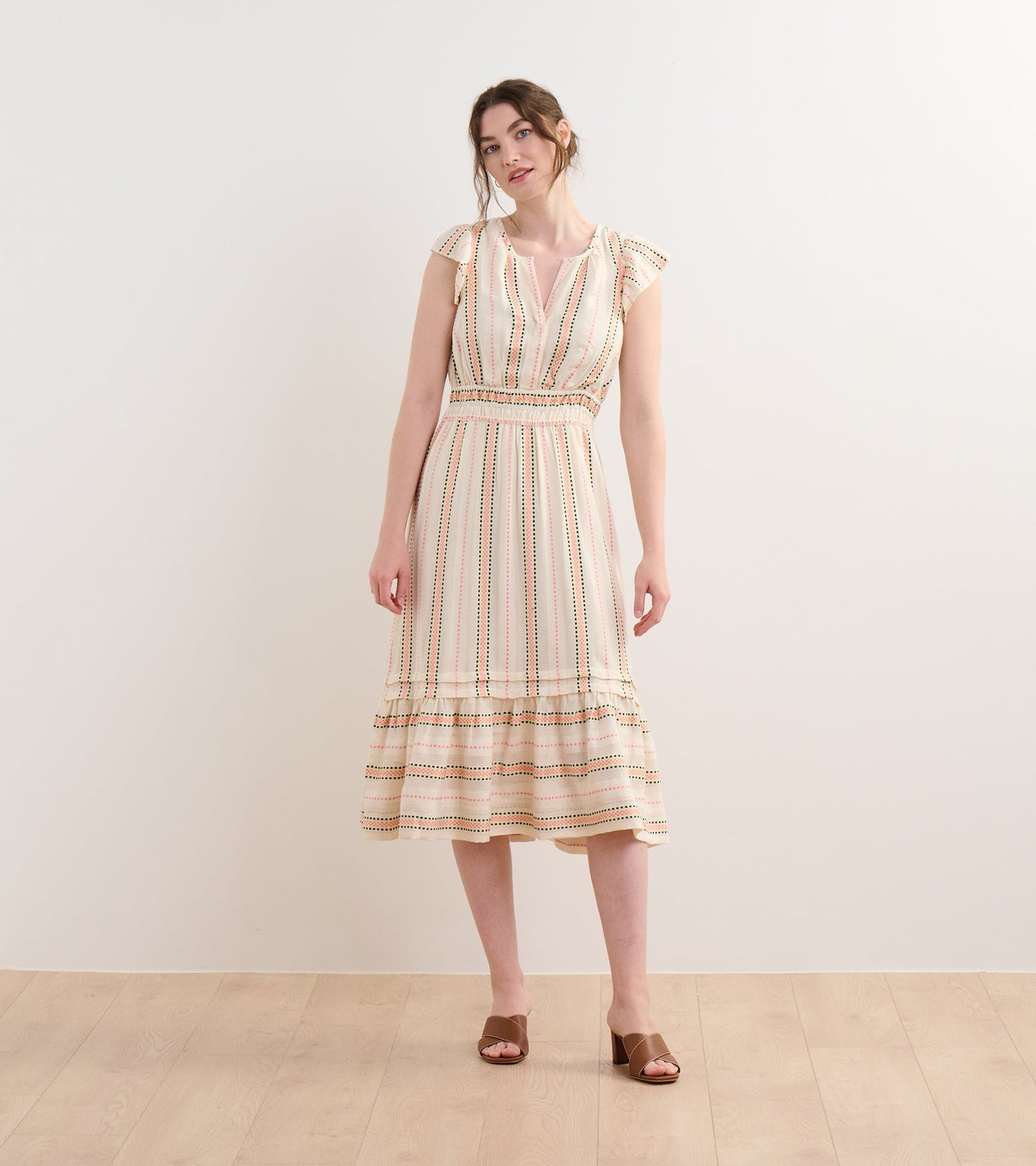 Midi dress featuring ribbon weave stripes in soft colors, with a fitted waist and flared skirt, styled with flutter sleeves.