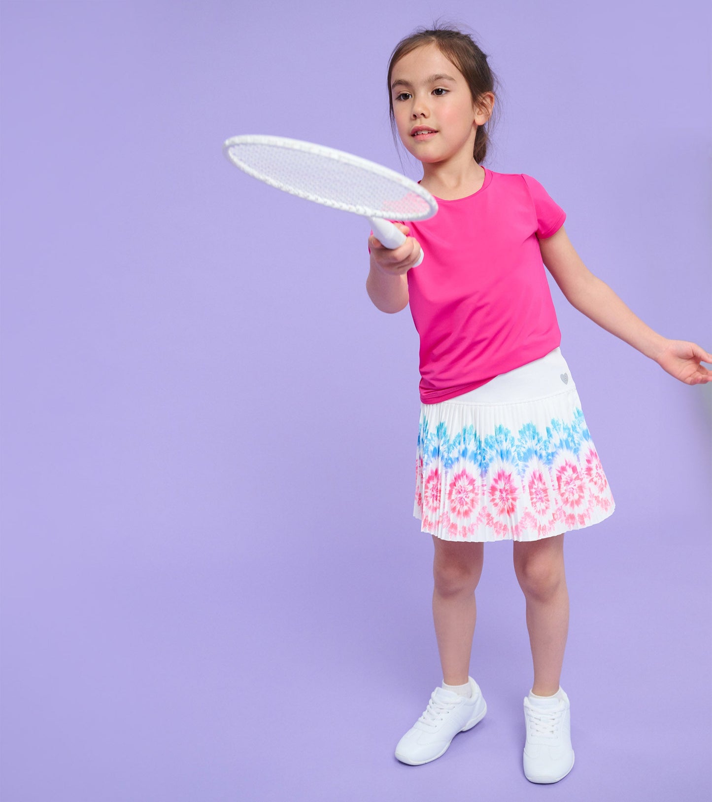 Pleated skort with a colorful sunburst pattern in pink and blue, paired with a pink top, suitable for active play.