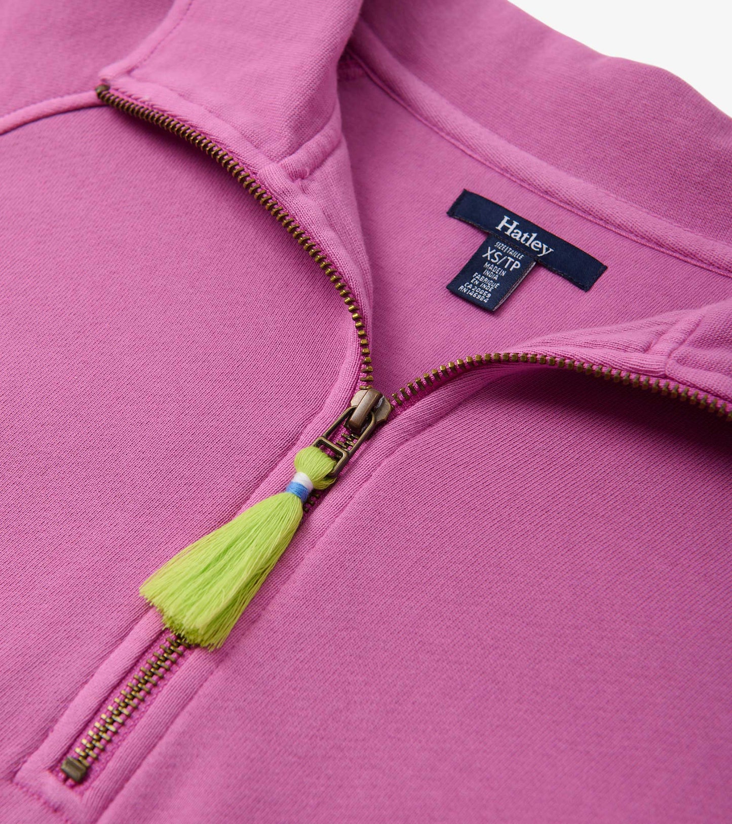 Pink mock neck pullover featuring a zip closure and a decorative tassel at the zipper. Soft fabric texture visible.