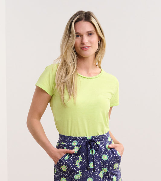 Sharp green braided neck tee with short sleeves, paired with patterned navy shorts.