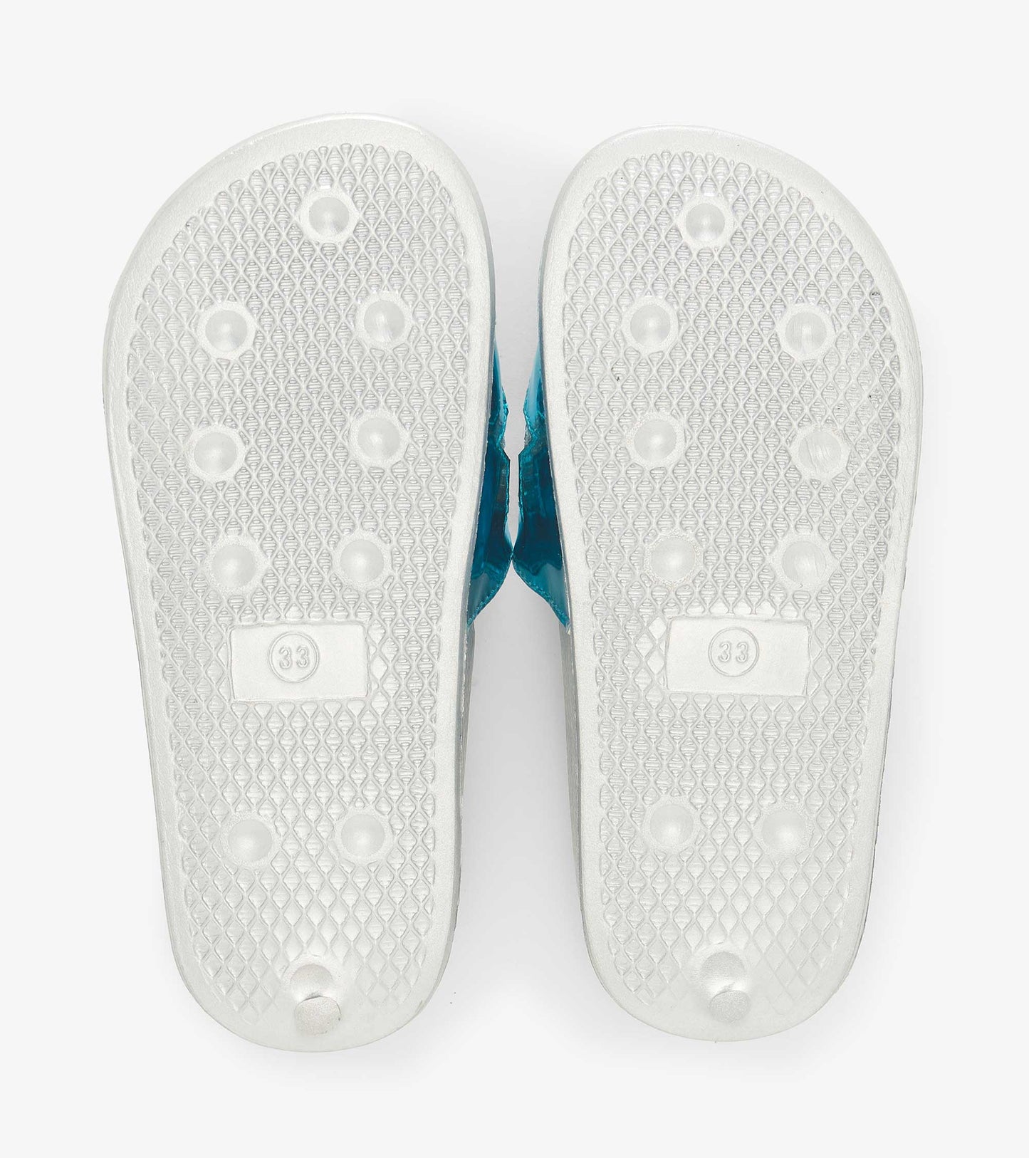 White rubber soles with textured grip and blue straps, designed for kids' casual wear.