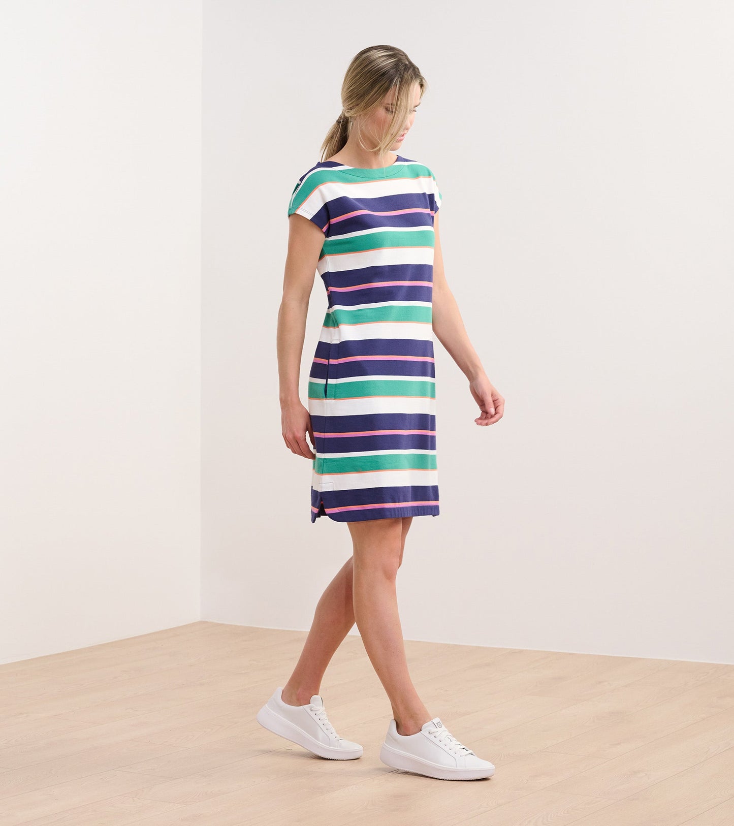 Short-sleeve dress featuring horizontal stripes in green, blue, purple, and white, styled with white sneakers.
