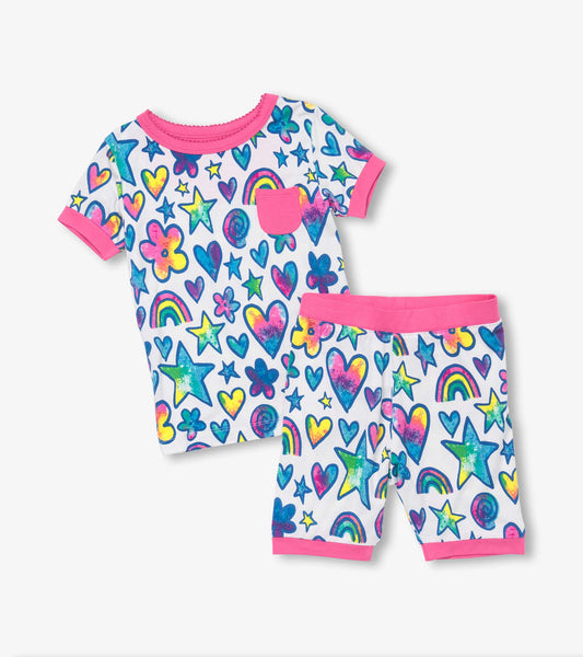 Short pajama set featuring a colorful watercolor doodle pattern with hearts, stars, and rainbows on a white background.