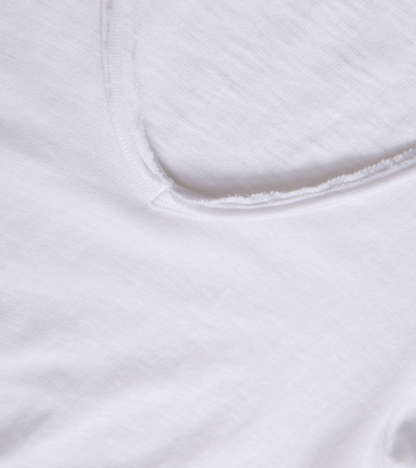 White V-neck tee with a soft, lightweight fabric and a relaxed fit. Close-up view of the neckline.