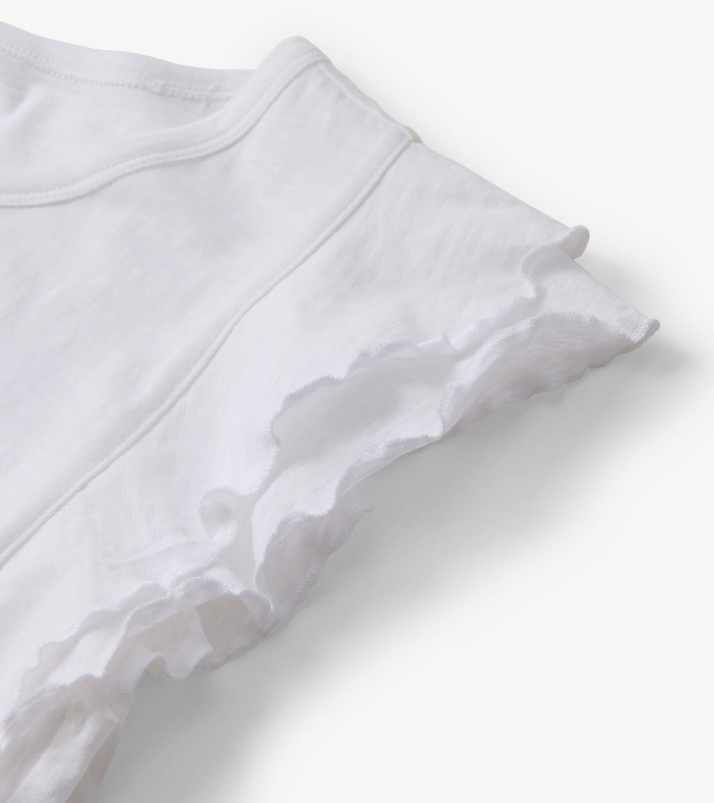 White tank top featuring layered ruffle sleeves, made from lightweight fabric.