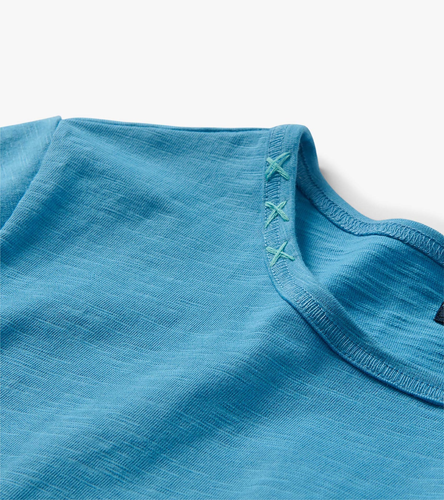 Close-up of the azure midi T-shirt dress neckline with contrast X-stitch detail