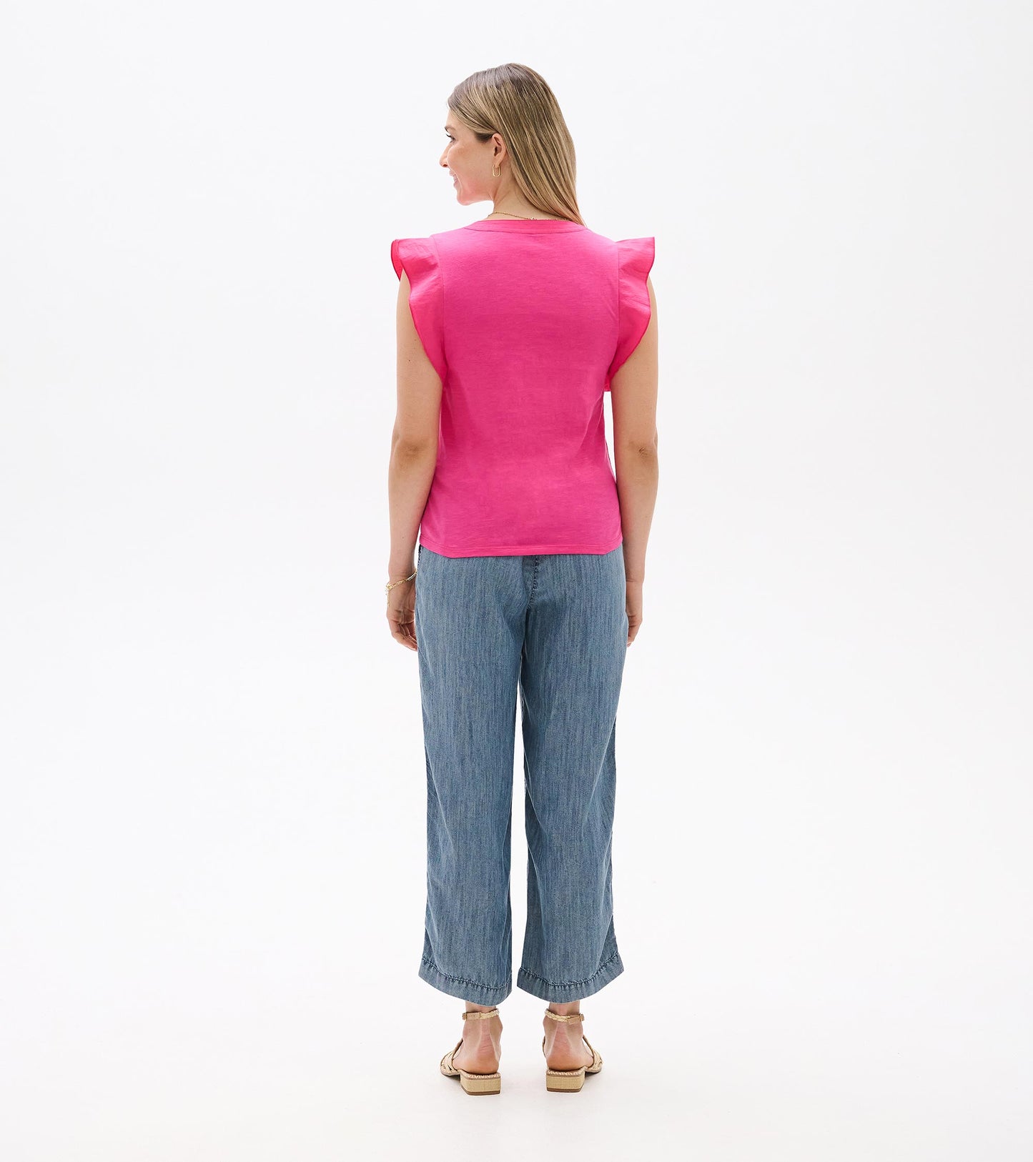Back view of a bright pink sleeveless tank top with ruffled shoulders and a straight hem