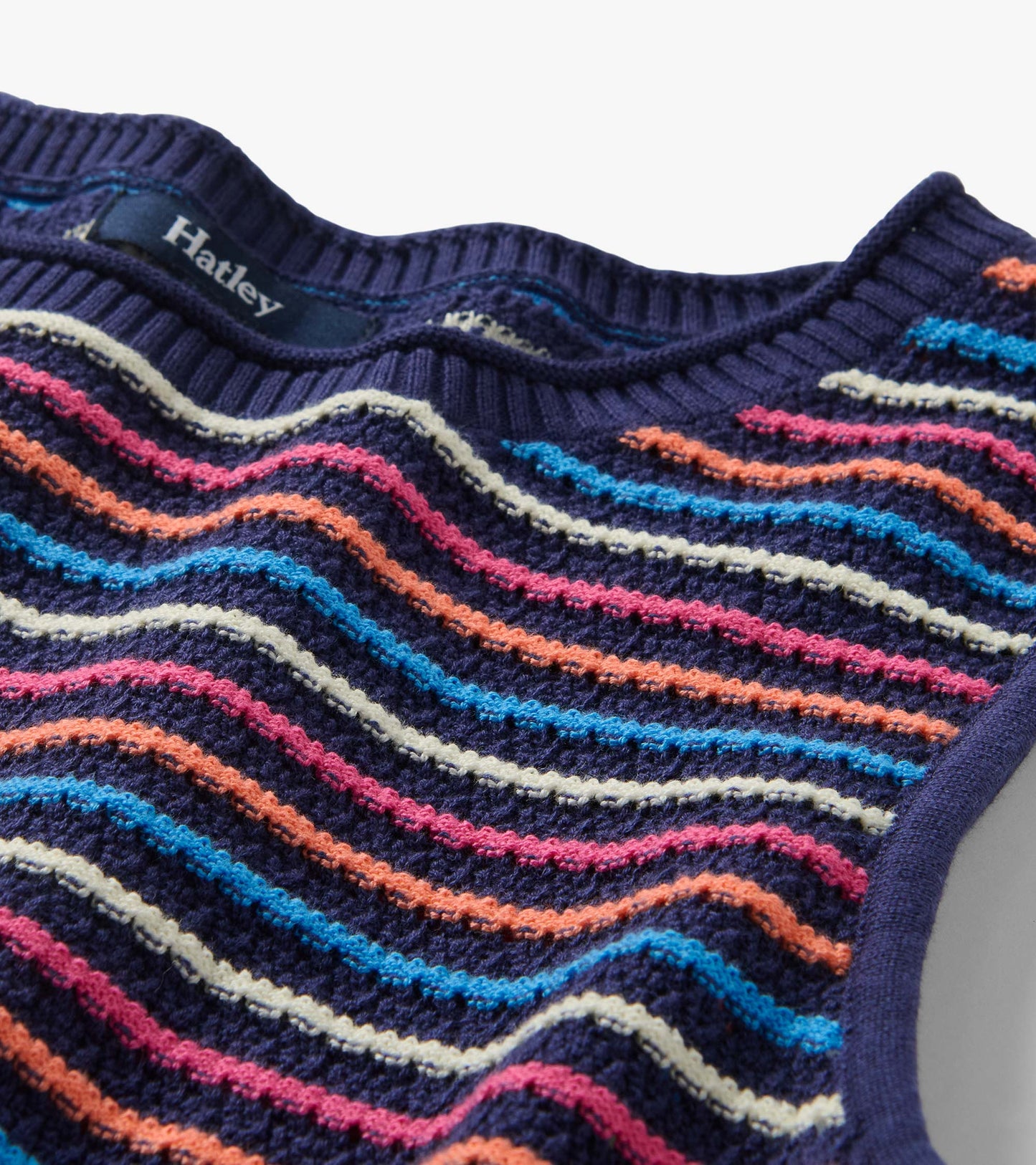 Sleeveless knit tank top with navy base and multicolor wavy stripes, close-up front view