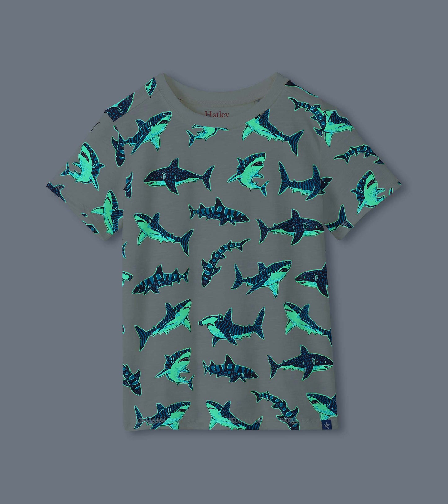 Cream shark print boys tee shown in the dark with glowing shark outlines
