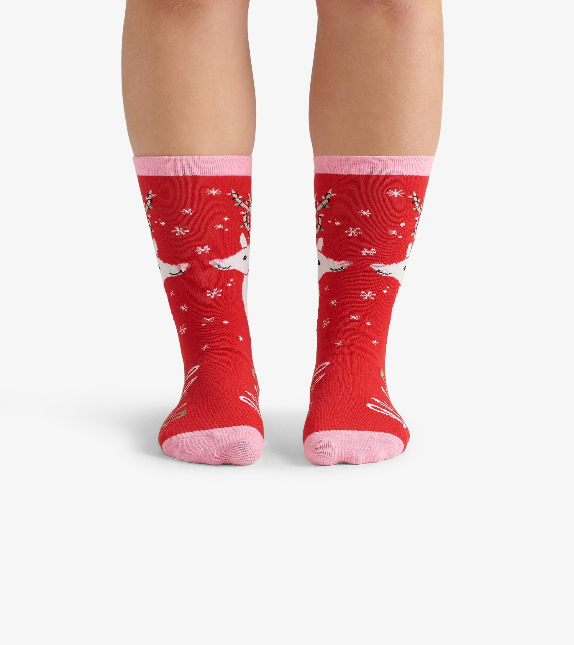 Red crew socks featuring white deer and snowflake patterns, with pink cuffs and soles, suitable for casual wear.