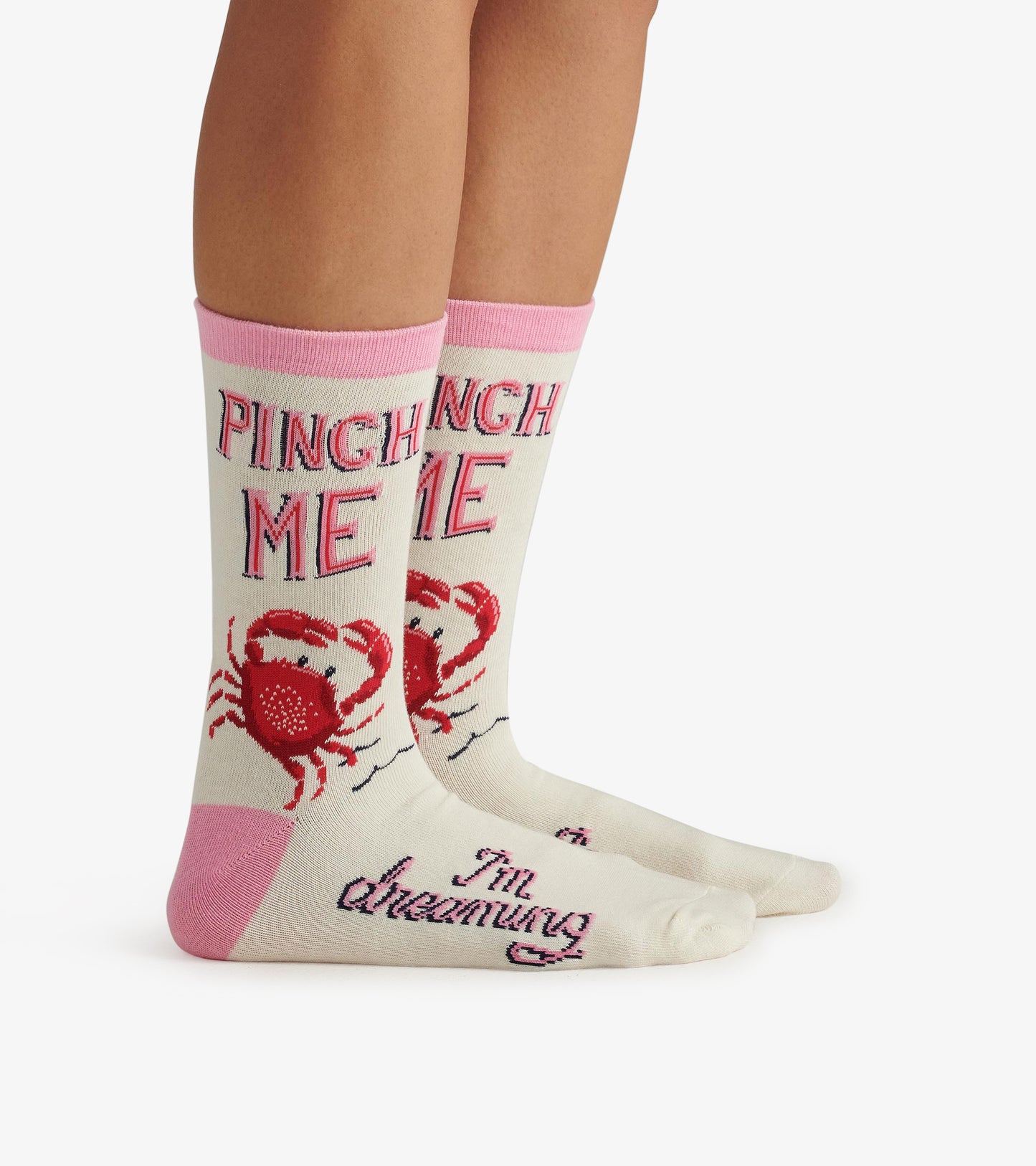 Cream crew socks with pink accents, featuring a crab design and the text "PINCH ME" and "I'm dreaming.