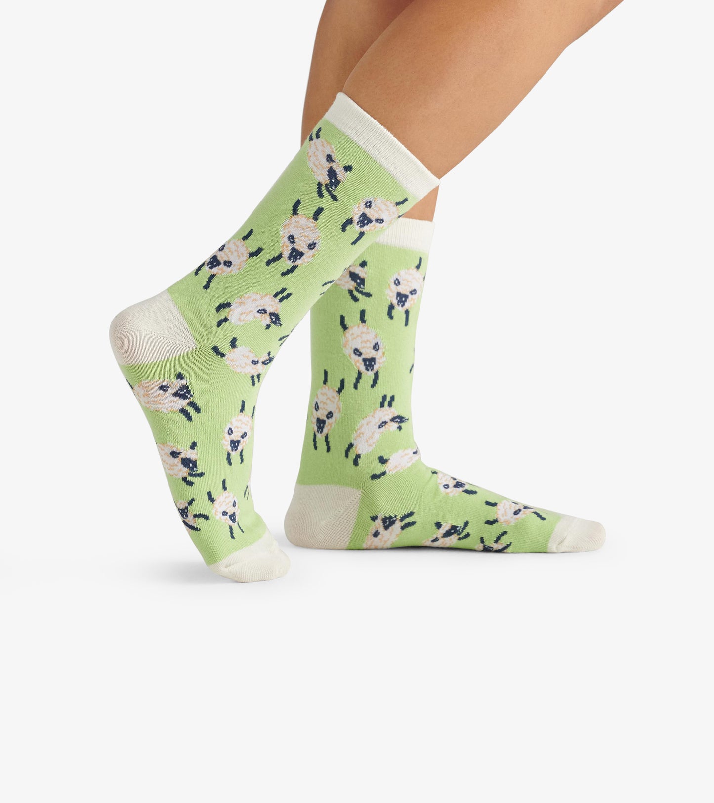 Light green crew socks featuring a playful sheep pattern, with contrasting white cuffs and toes.