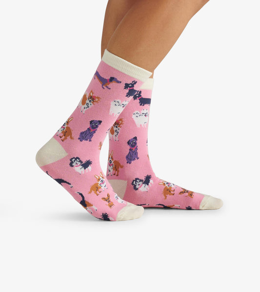 Pink crew socks featuring a playful pattern of various colorful dogs with a cream-colored cuff.