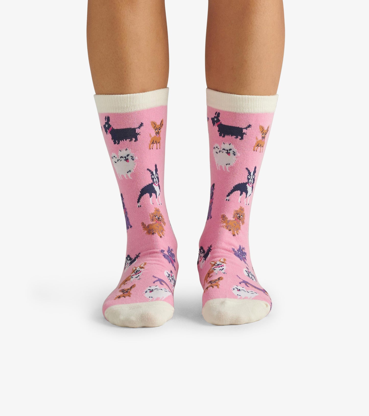 Pink crew socks featuring various cheerful dog illustrations, with a contrasting white cuff. One size fits most.
