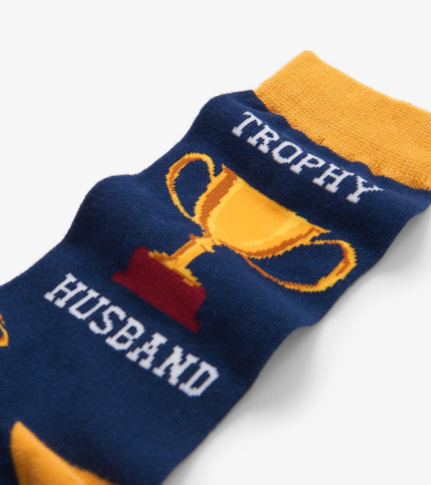 Navy crew socks featuring a trophy graphic with "TROPHY HUSBAND" text and a yellow cuff. One size fits all.