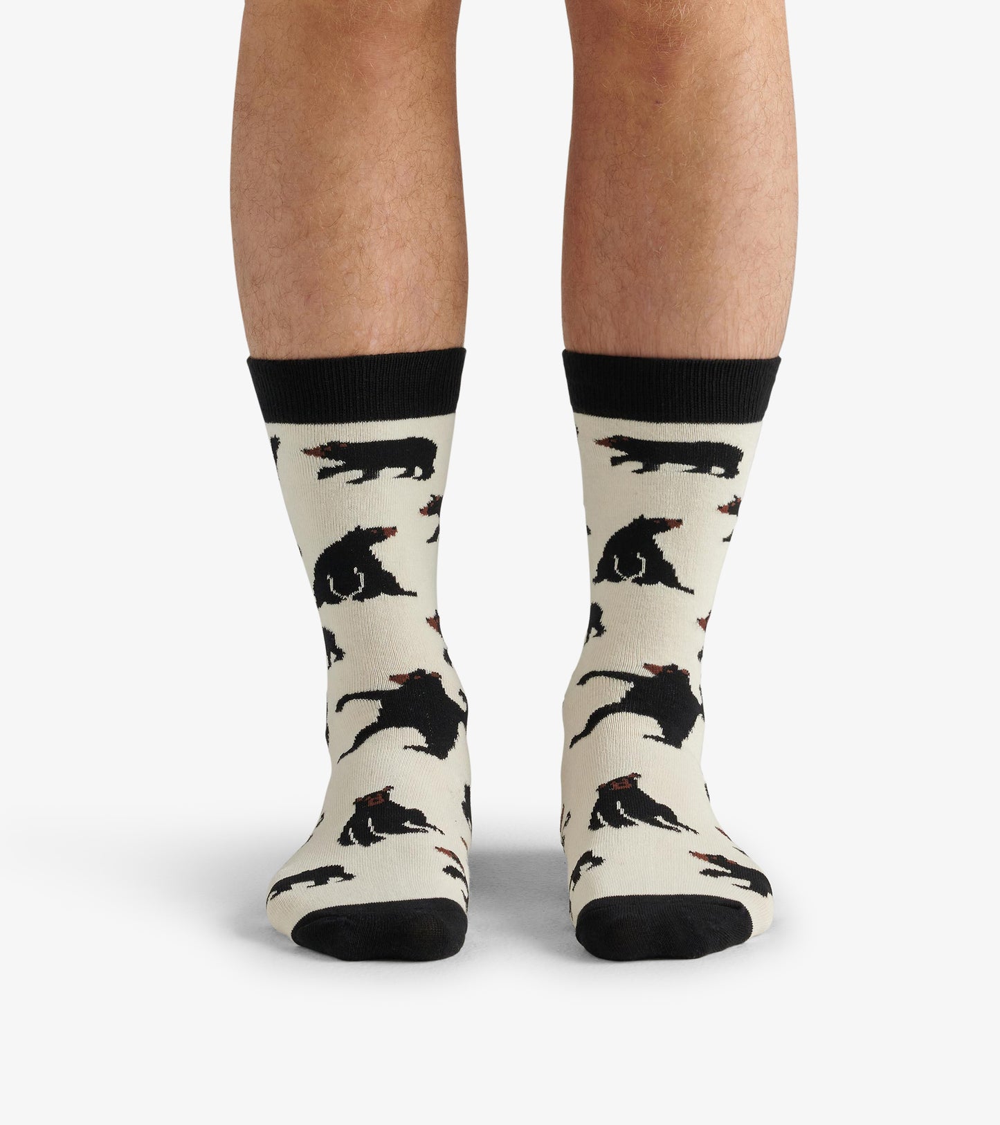 Cream crew socks featuring black bear patterns and black ribbed cuffs, worn on a pair of legs.