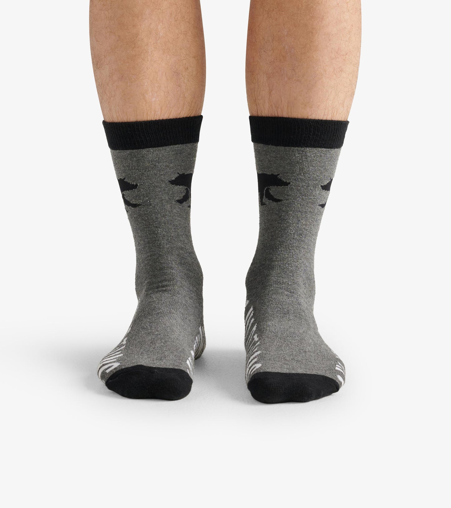 Gray crew socks with black animal print and contrasting black cuffs, shown on a pair of legs.