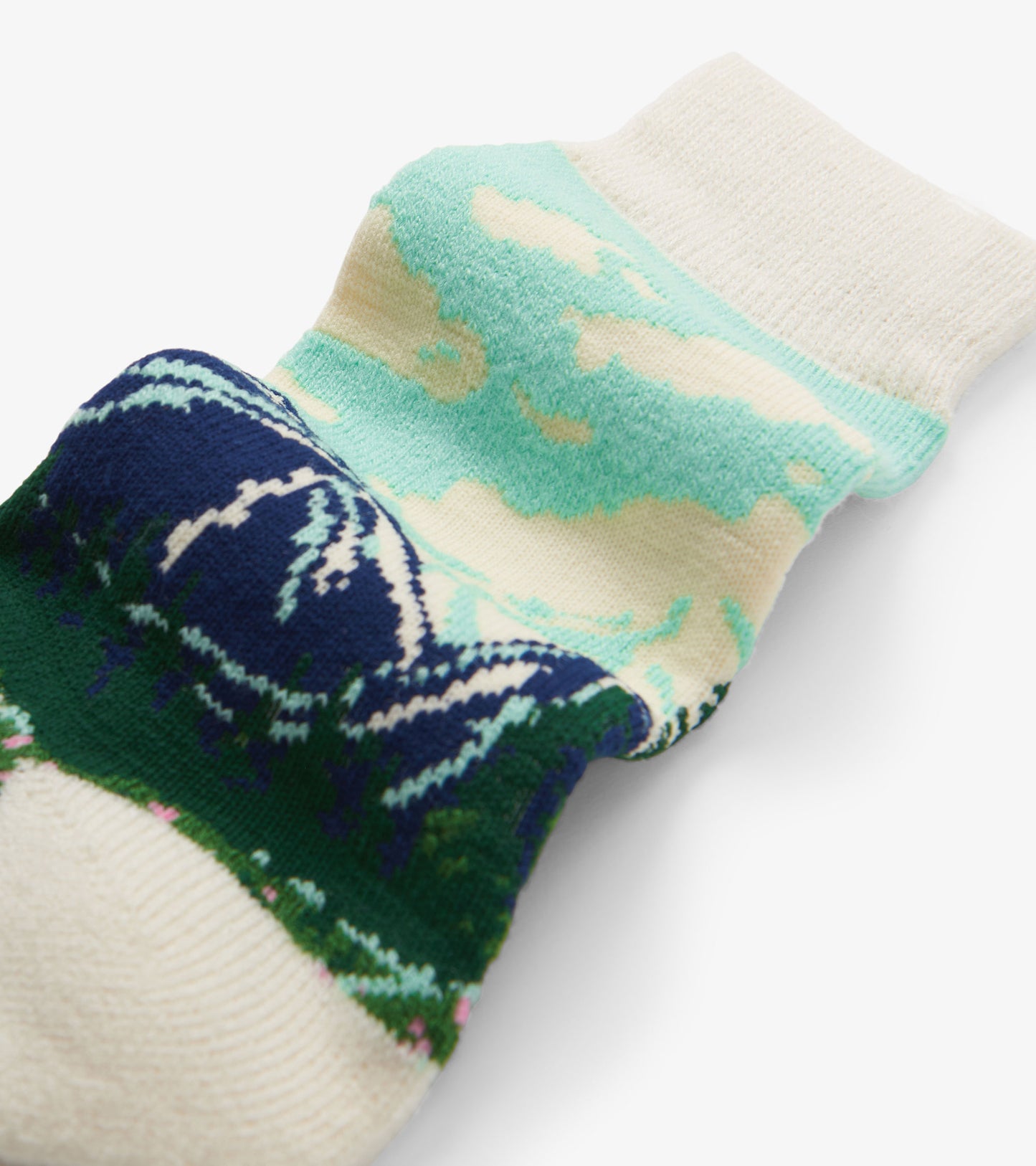 Cream cozy socks with mint and navy mountain pattern, close-up view of cuff and leg.