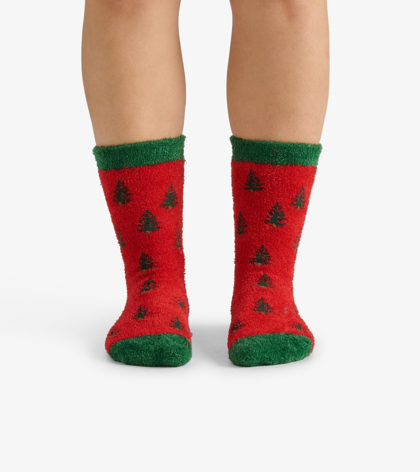 Red fuzzy socks with green cuffs, featuring a pattern of black trees, designed for adult wear.