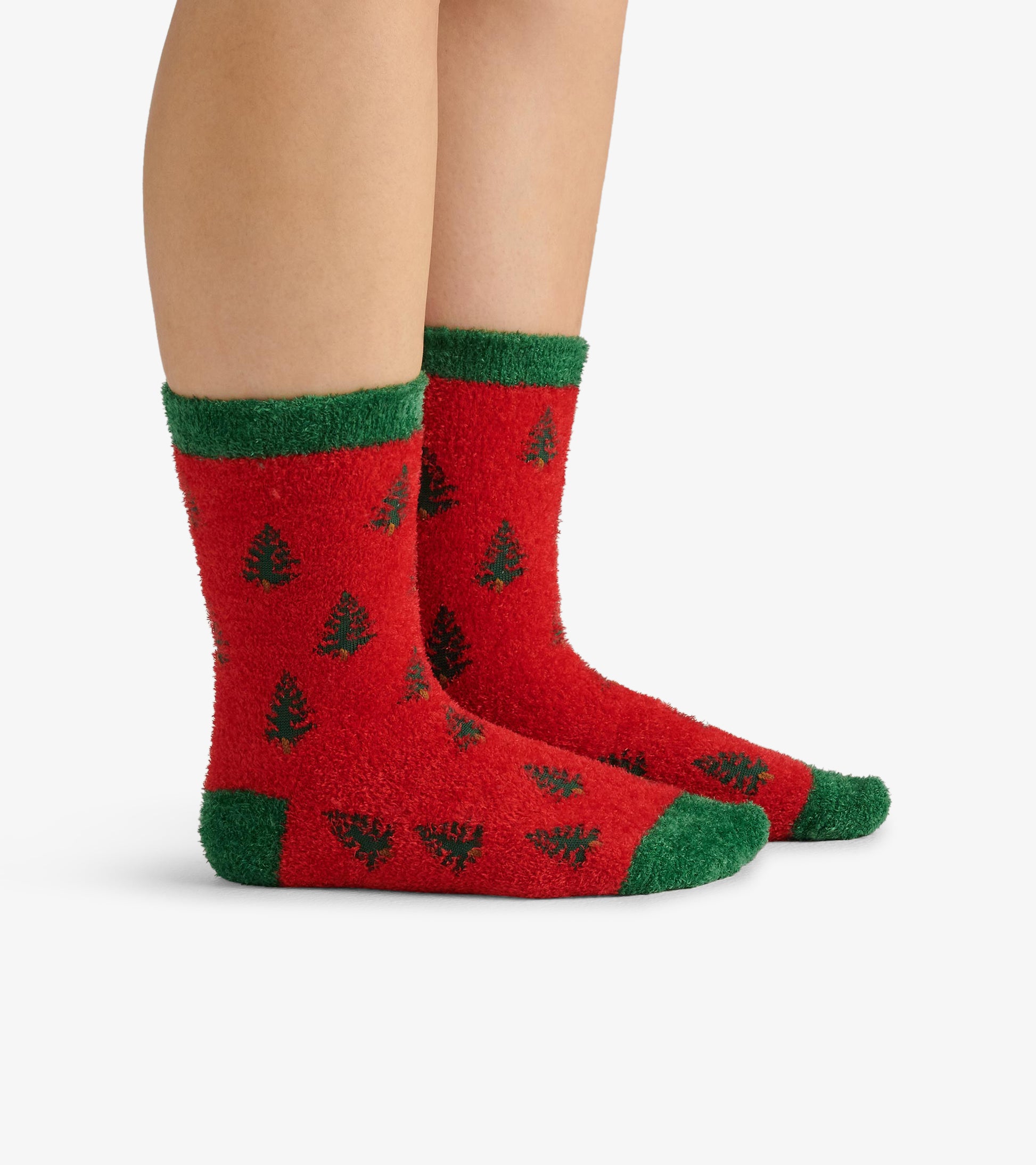 Red fuzzy socks with green cuffs, featuring a tree pattern, suitable for adults.