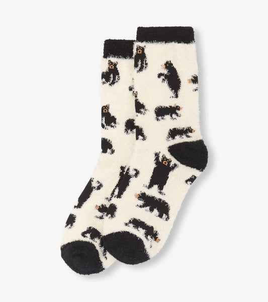 Fuzzy cream socks featuring black bear patterns and black cuffs, perfect for cozy wear. One size fits most.