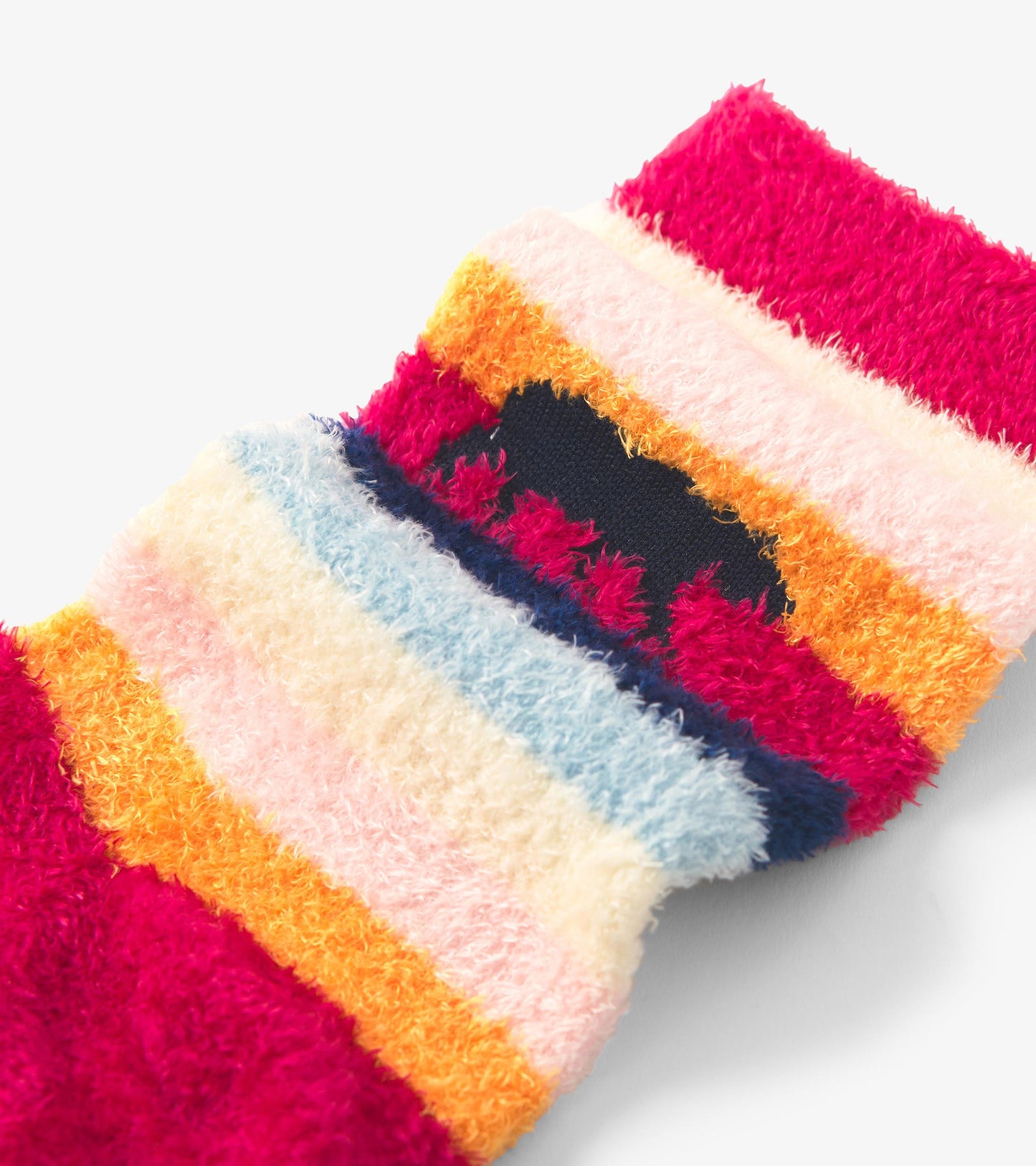 Fuzzy socks featuring a colorful striped pattern in pink, orange, blue, and cream shades. One size fits all.