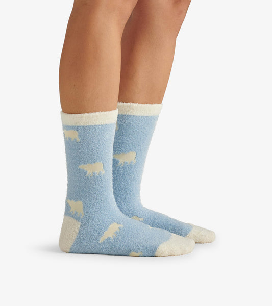 Fuzzy blue socks featuring white polar bear patterns and cream-colored cuffs, designed for comfort and warmth.