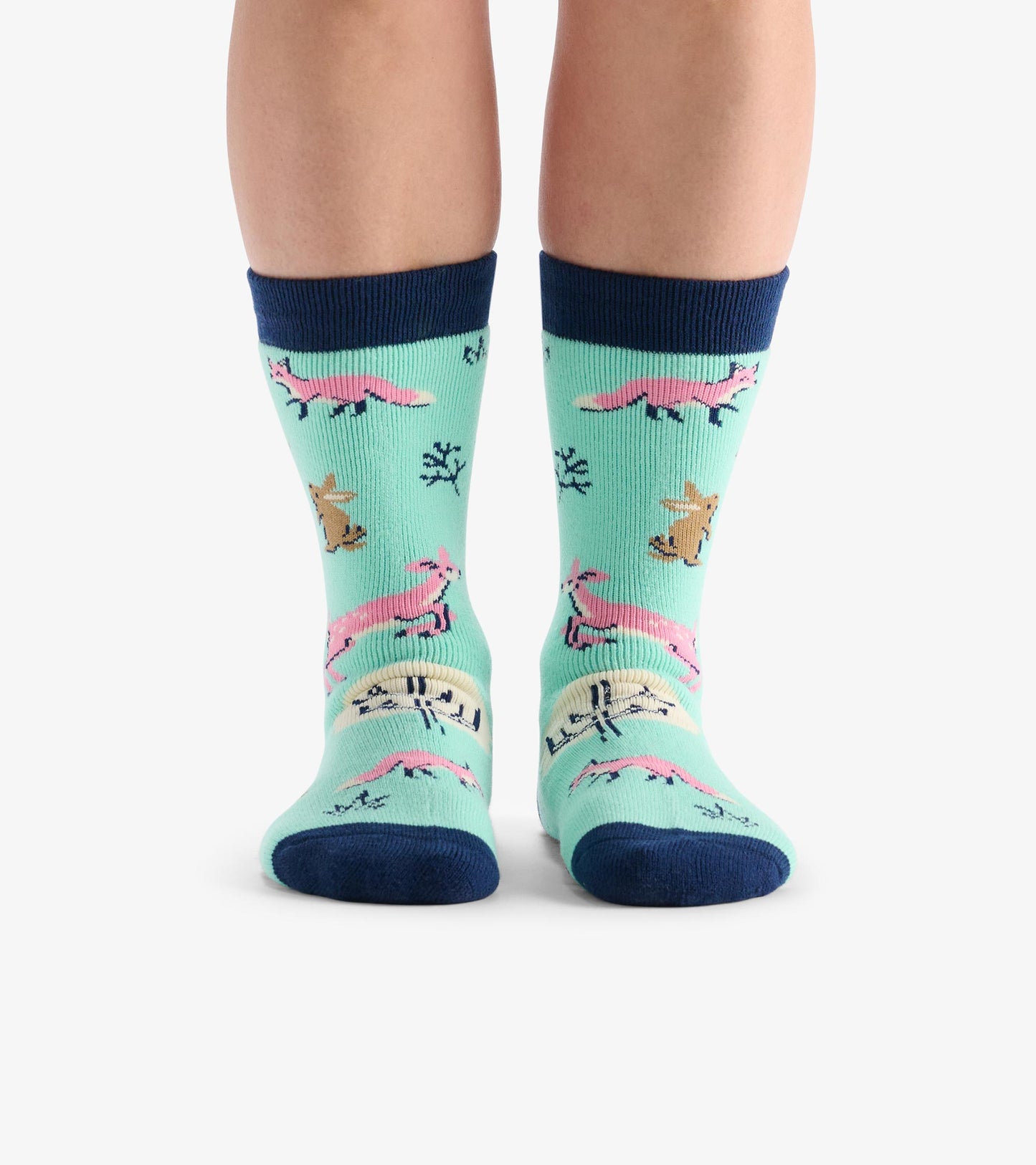 Light blue cozy socks featuring pink foxes and brown deer, with navy ribbed cuffs and a playful forest animal pattern.