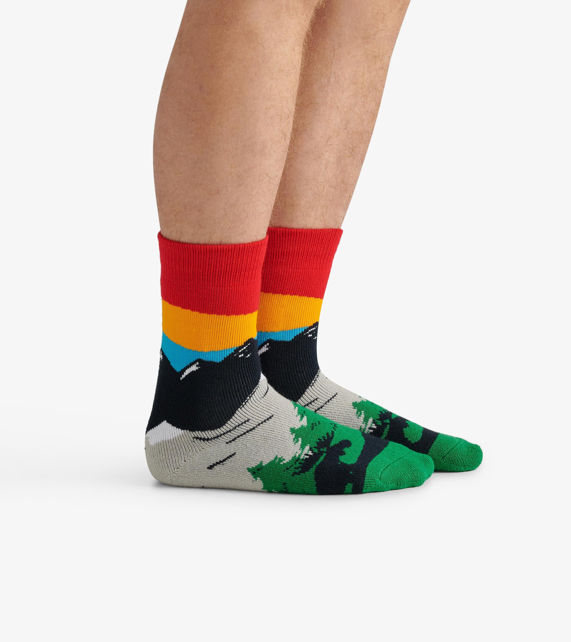 Colorful hiking socks featuring a mountain and forest design with red, yellow, and blue accents. One size fits all.