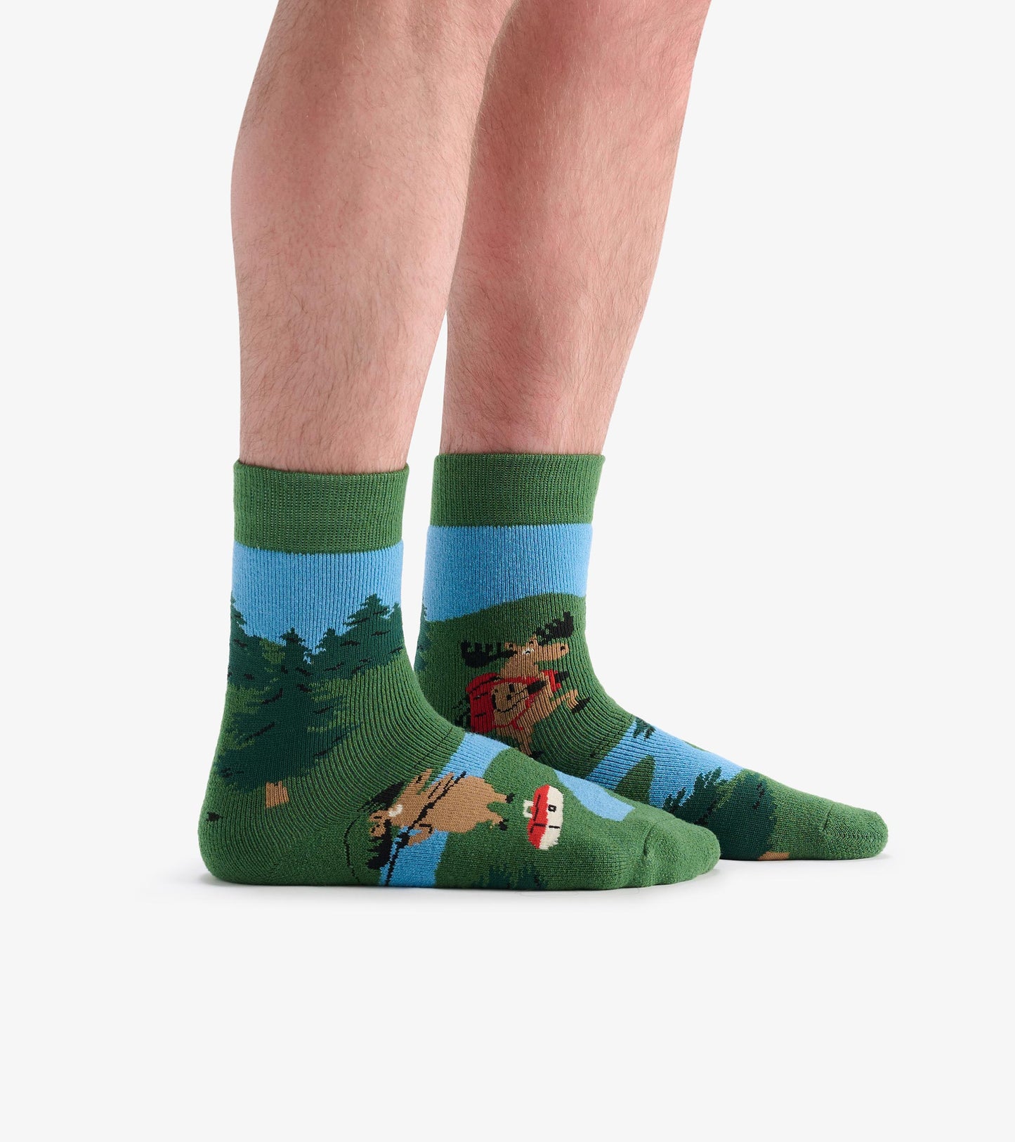 Green and blue cozy socks featuring a moose and forest scene, ideal for hiking or casual wear.
