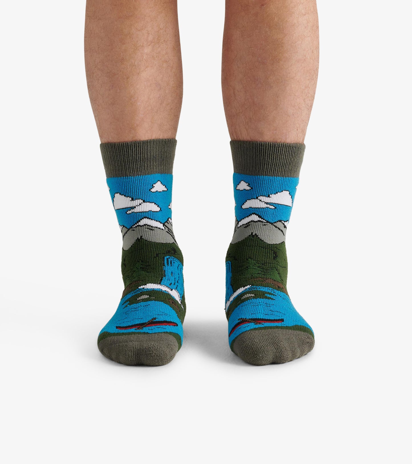 Cozy men's socks featuring a colorful mountain and sky pattern with green and blue hues. One size fits all.