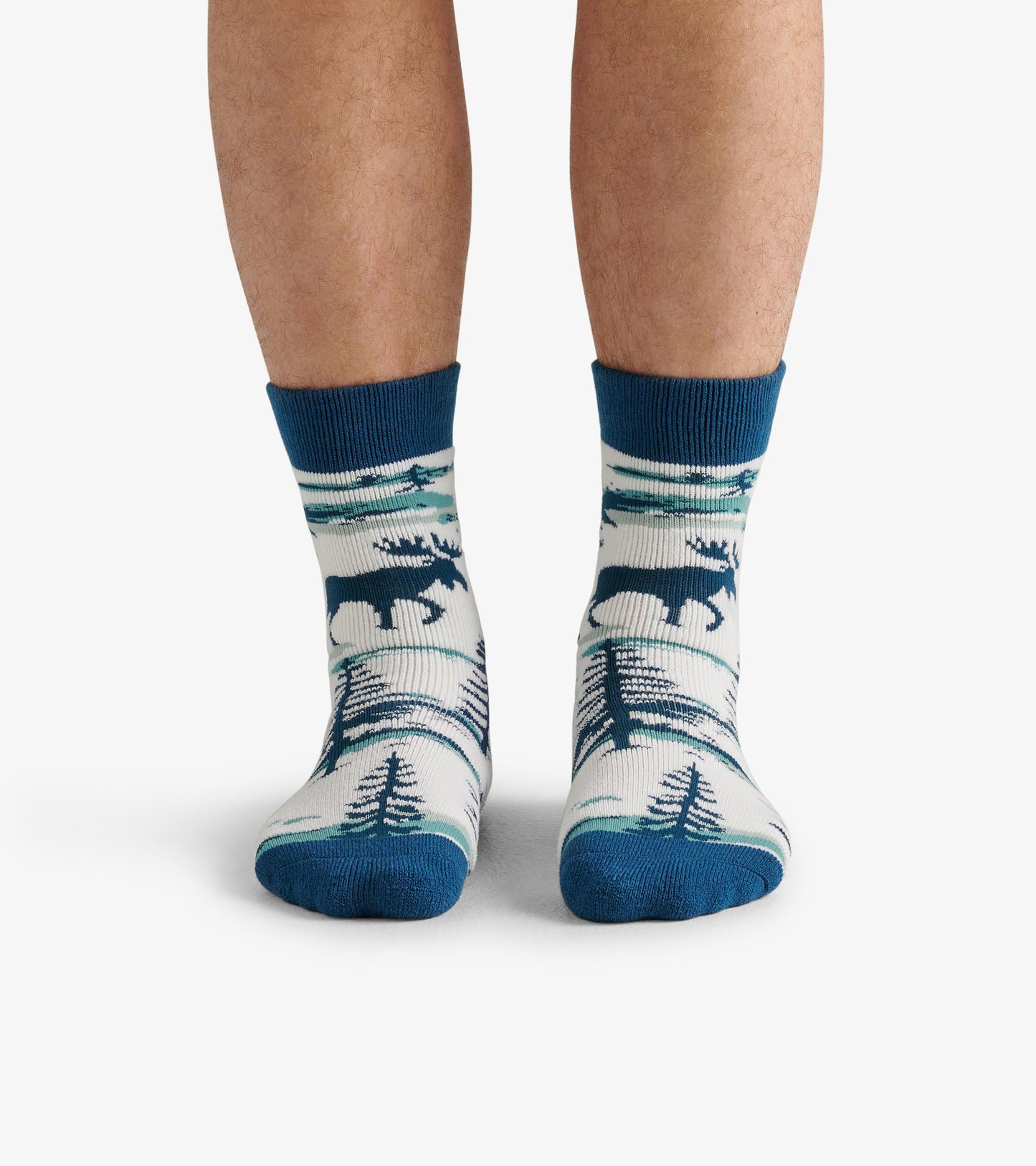 Cozy socks featuring a moose and tree pattern in blue and cream, designed for comfort and warmth.