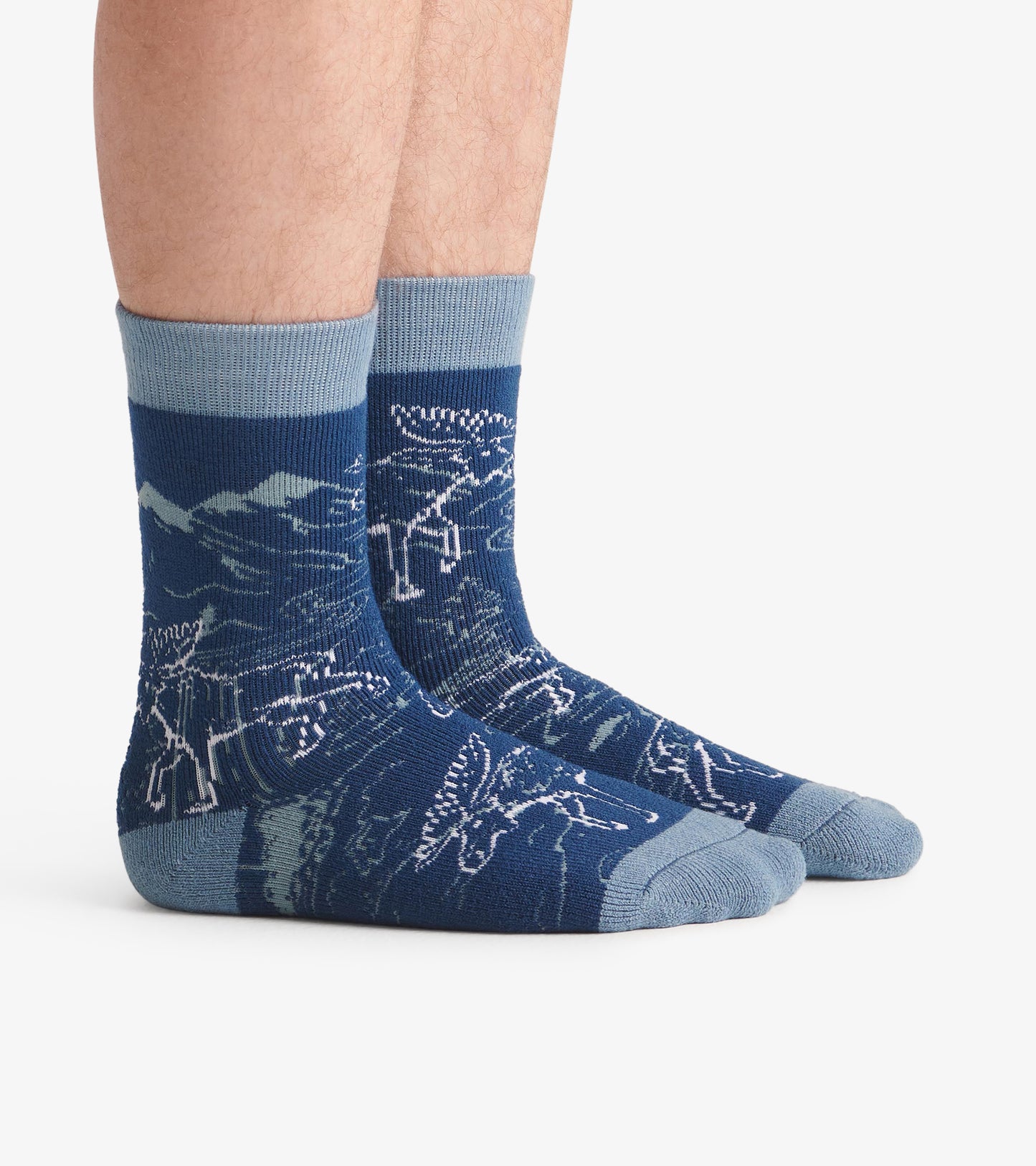 Cozy blue socks featuring a moose and mountain pattern, with a ribbed cuff and contrasting toe and heel.
