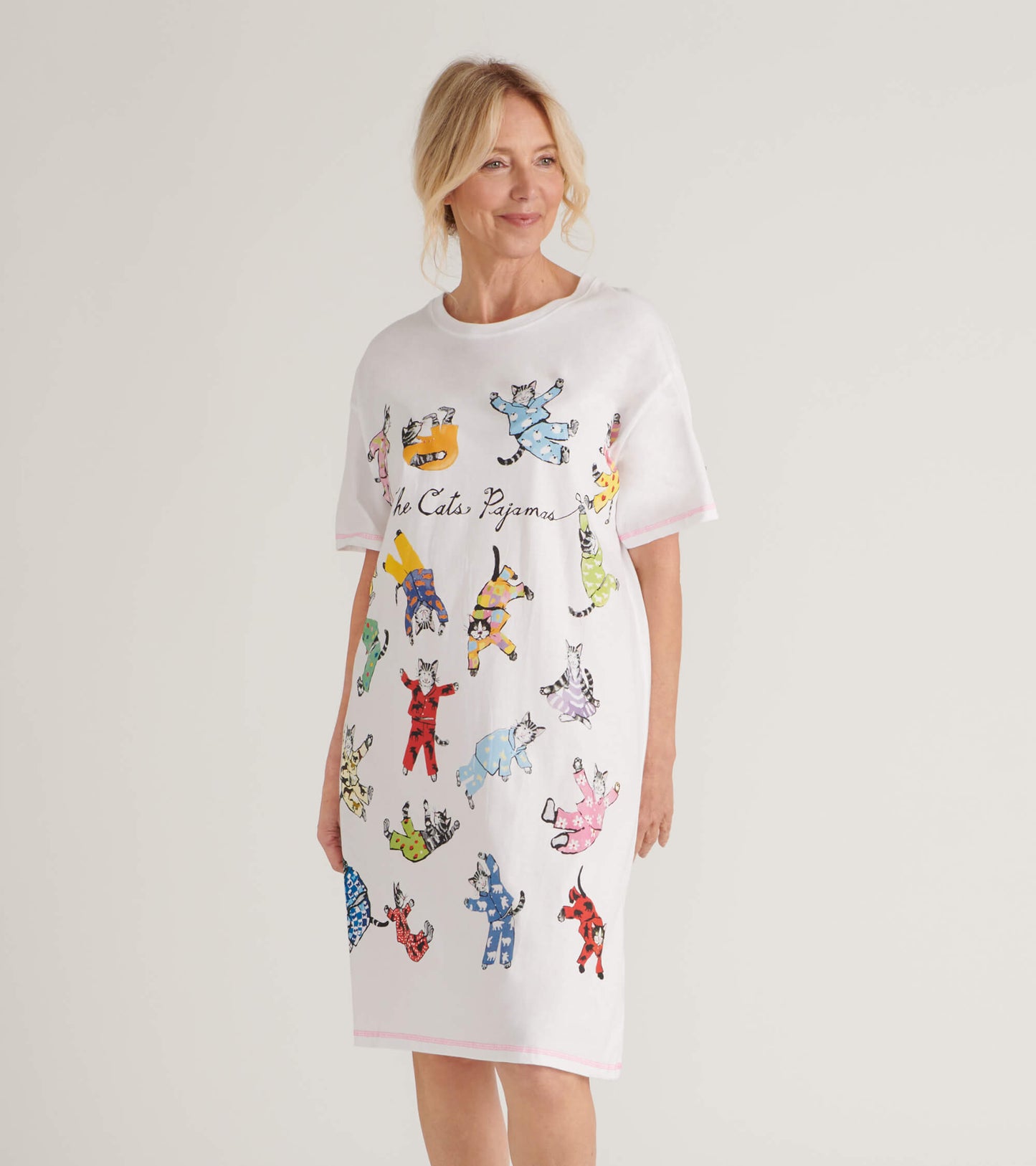 White sleepshirt featuring colorful cat illustrations, short sleeves, and a relaxed fit.
