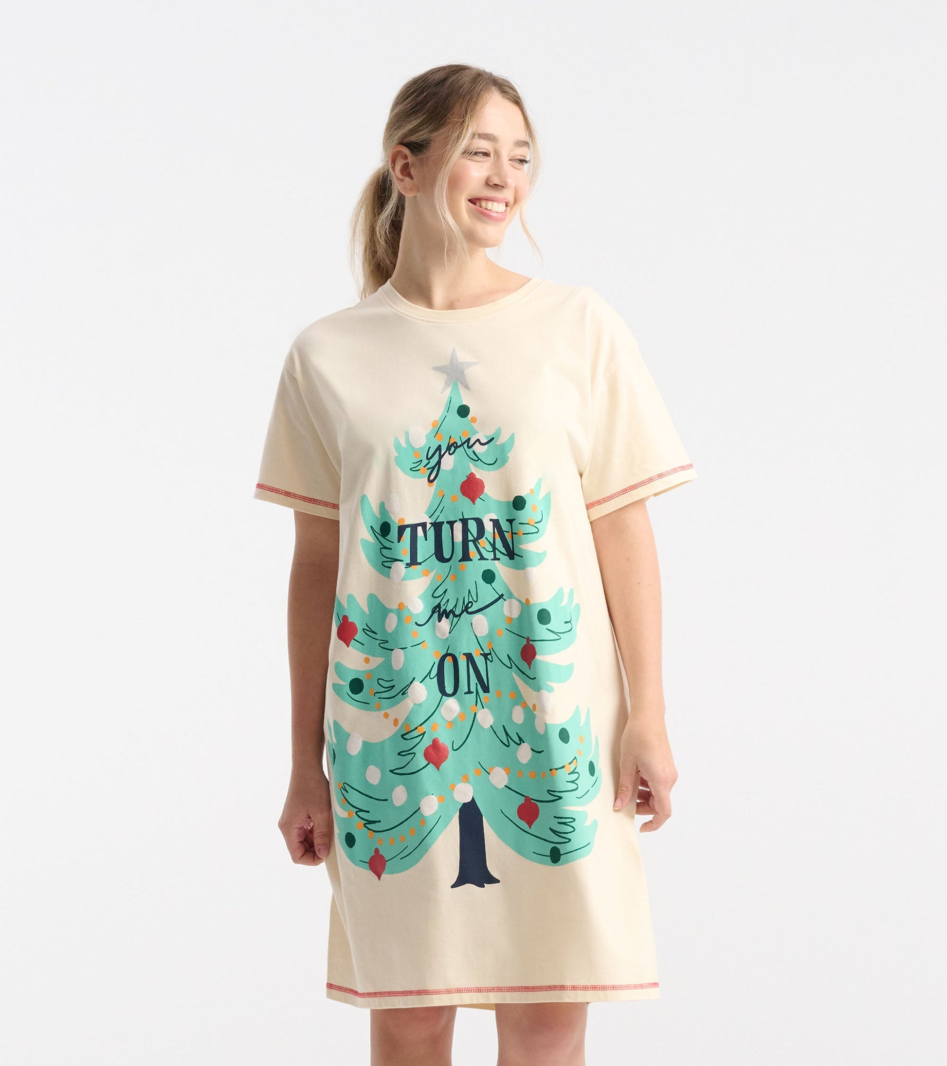Cream-colored sleepshirt featuring a colorful Christmas tree graphic with the text "TURN ON" and red trim.