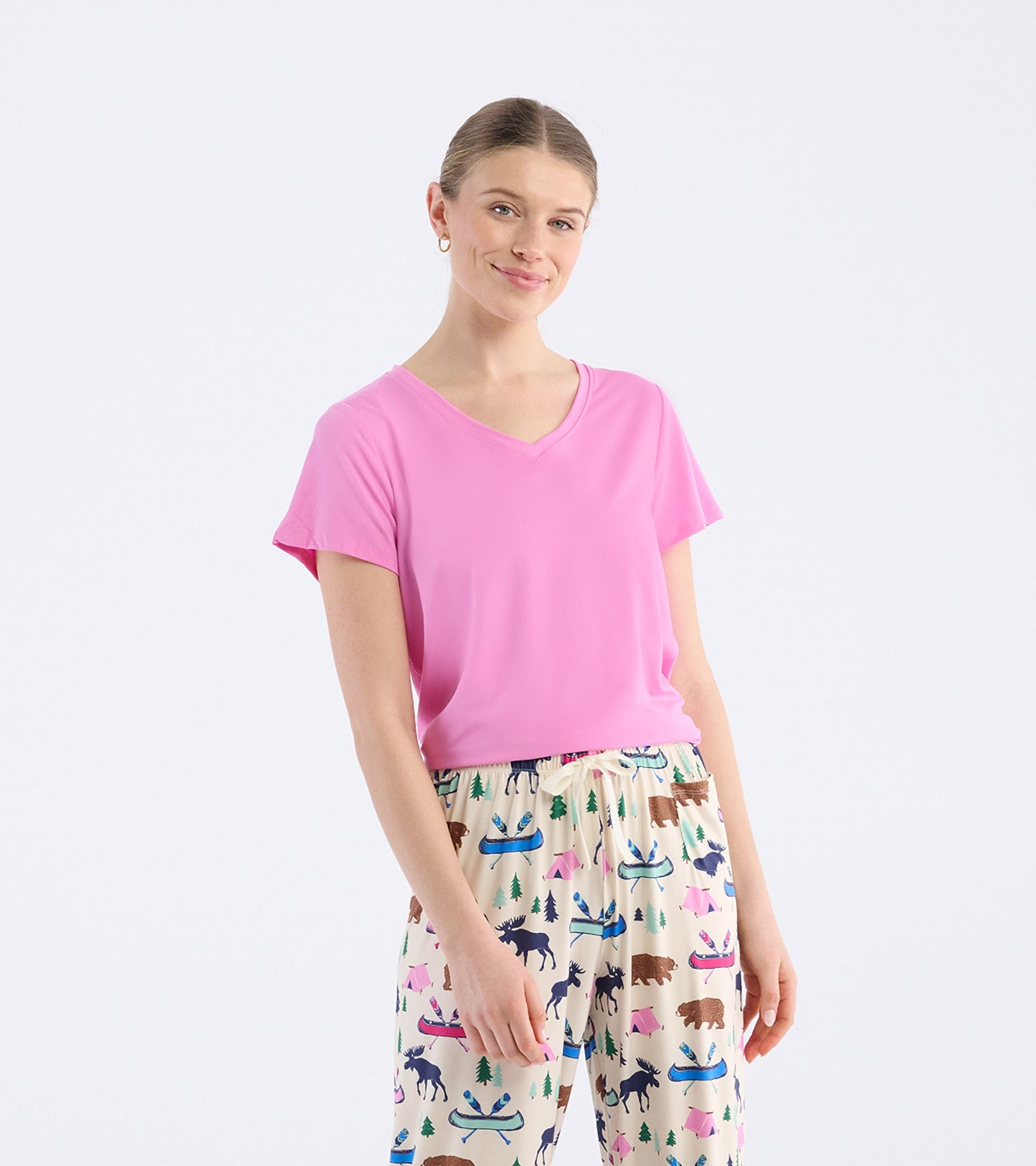 Pink V-neck t-shirt with short sleeves, paired with patterned pajama pants featuring animals and outdoor motifs.