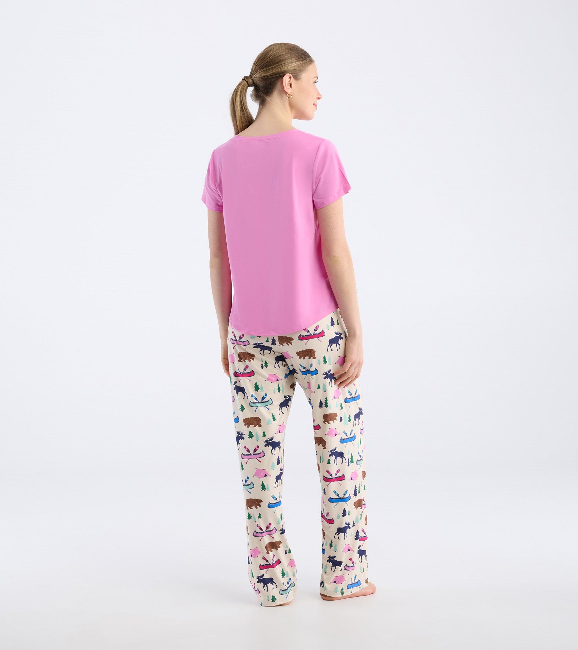Pink V-neck t-shirt with short sleeves, worn with patterned pajama pants, viewed from the back.