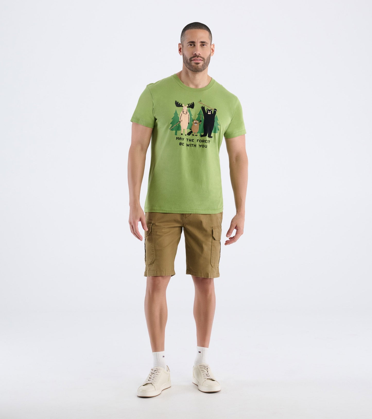Green men's t-shirt featuring a playful forest animal graphic, paired with khaki shorts and white sneakers.