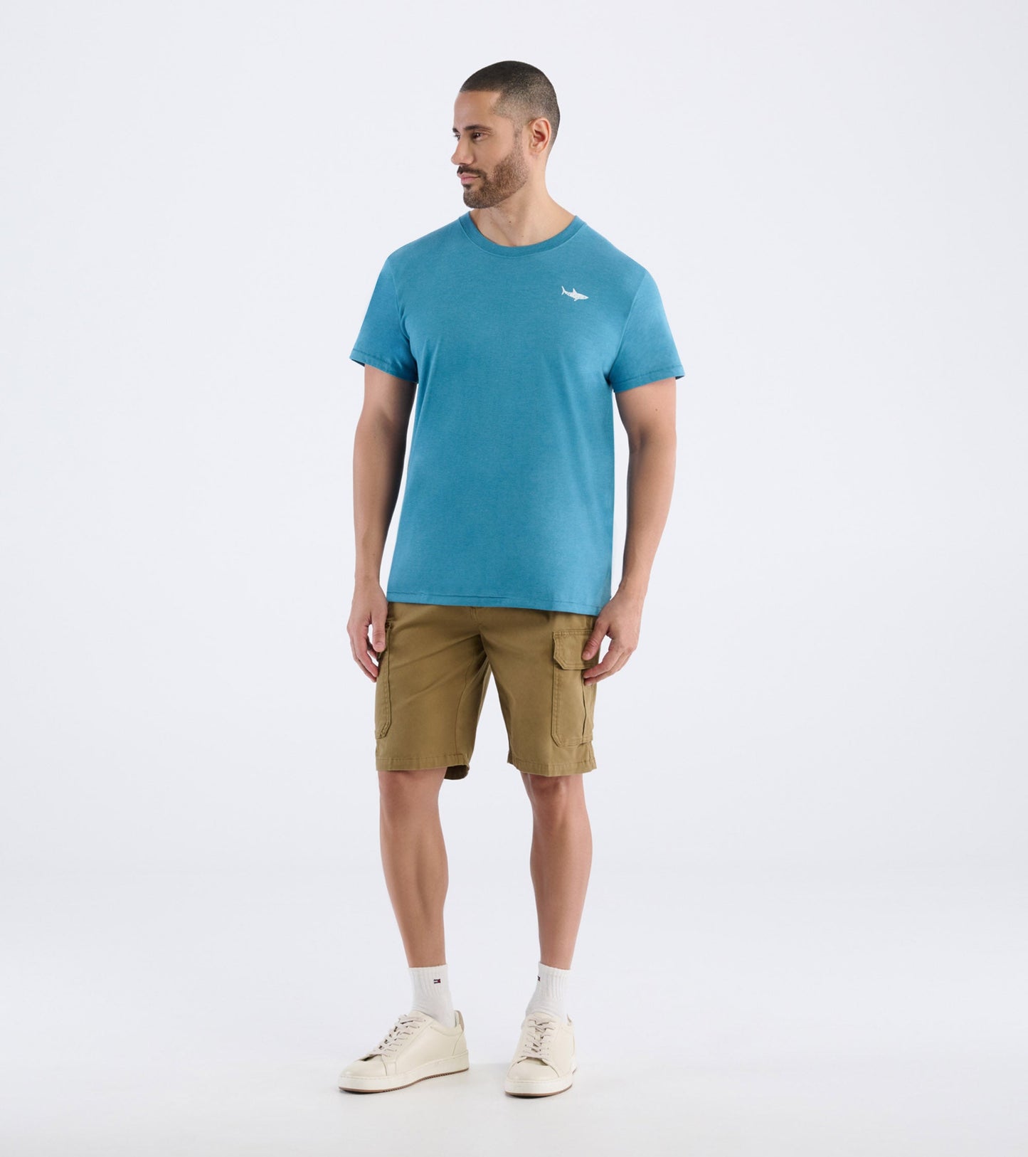 Teal short-sleeve men's tee with a crew neck and a small graphic on the chest, paired with khaki cargo shorts.