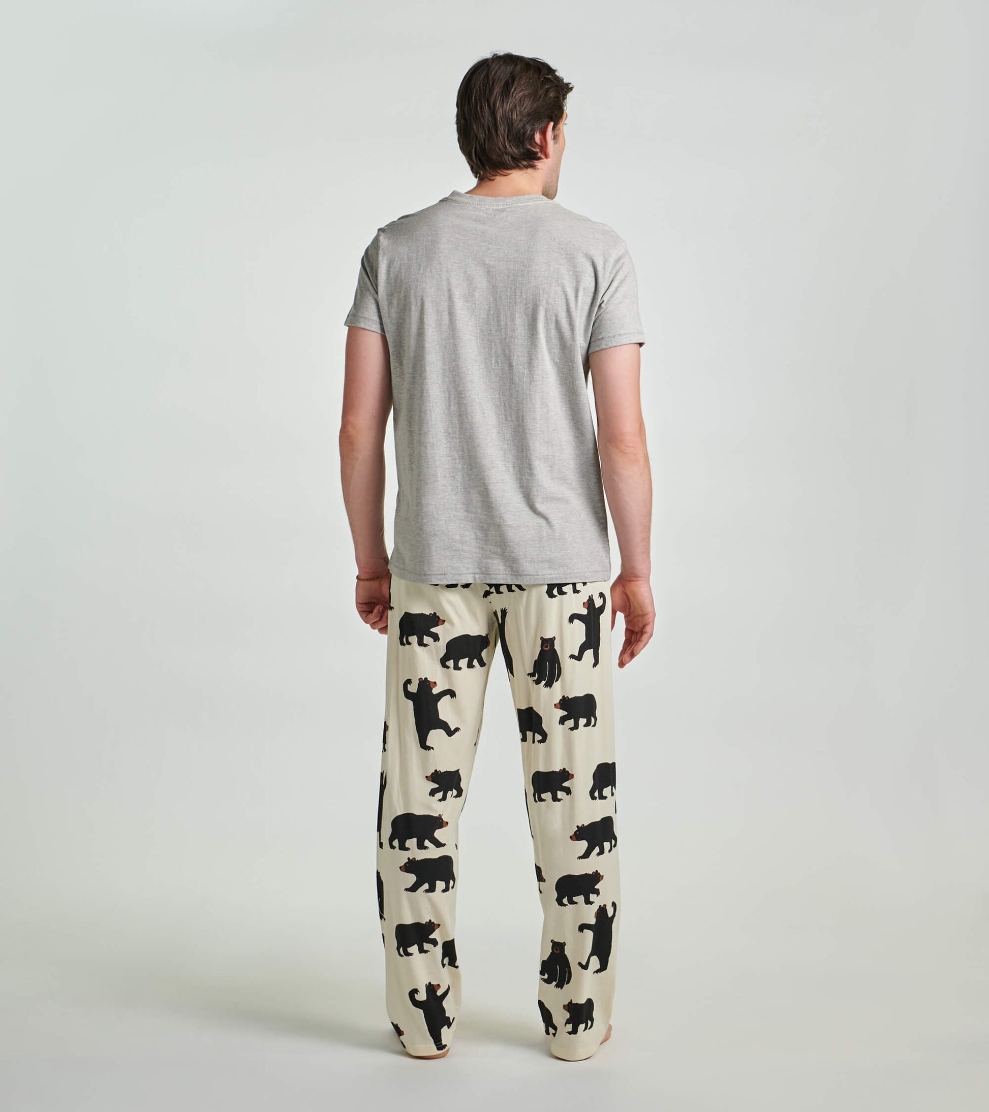 Grey men's tee featuring a black bear design, worn with patterned pajama pants, shown from the back.