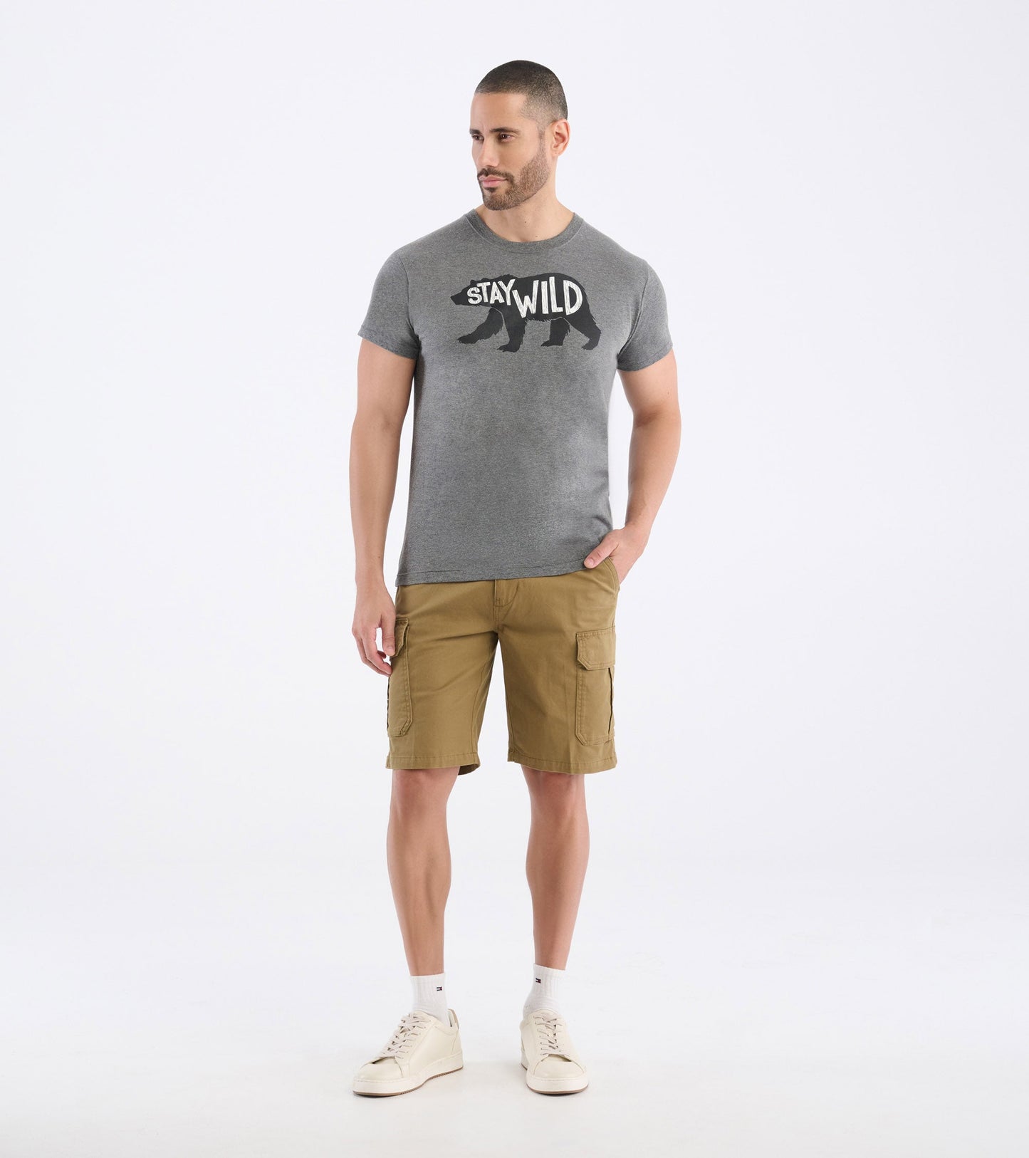 Gray short-sleeve tee featuring a bear graphic and "STAY WILD" text, paired with khaki shorts and white sneakers.