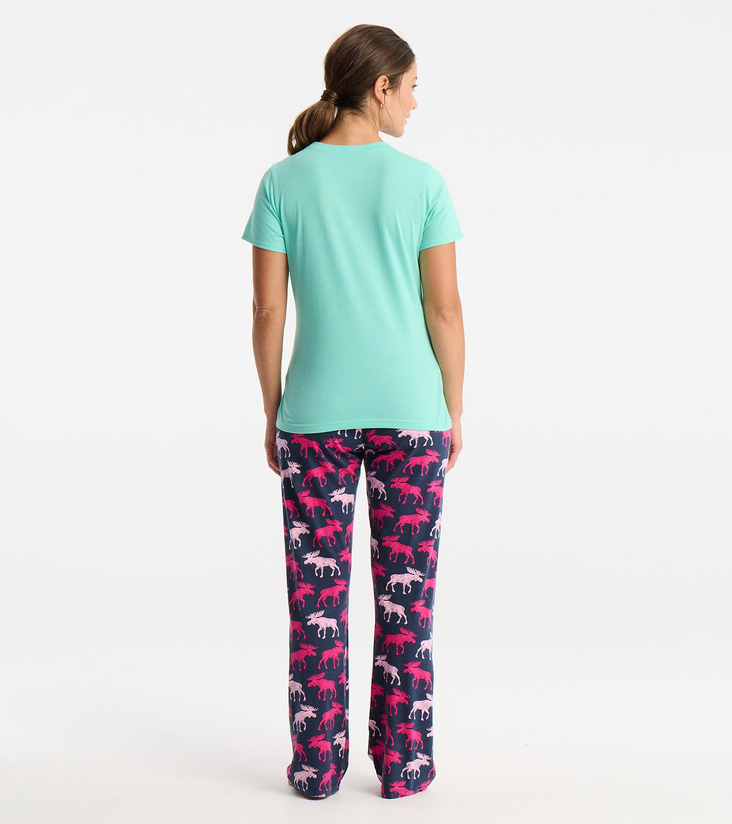 Mint green short-sleeve pajama t-shirt paired with navy pants featuring a colorful animal print, viewed from the back.