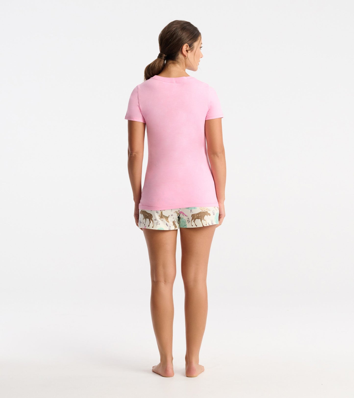 Pink short-sleeve pajama t-shirt, fitted style, worn with patterned shorts featuring animals and nature.