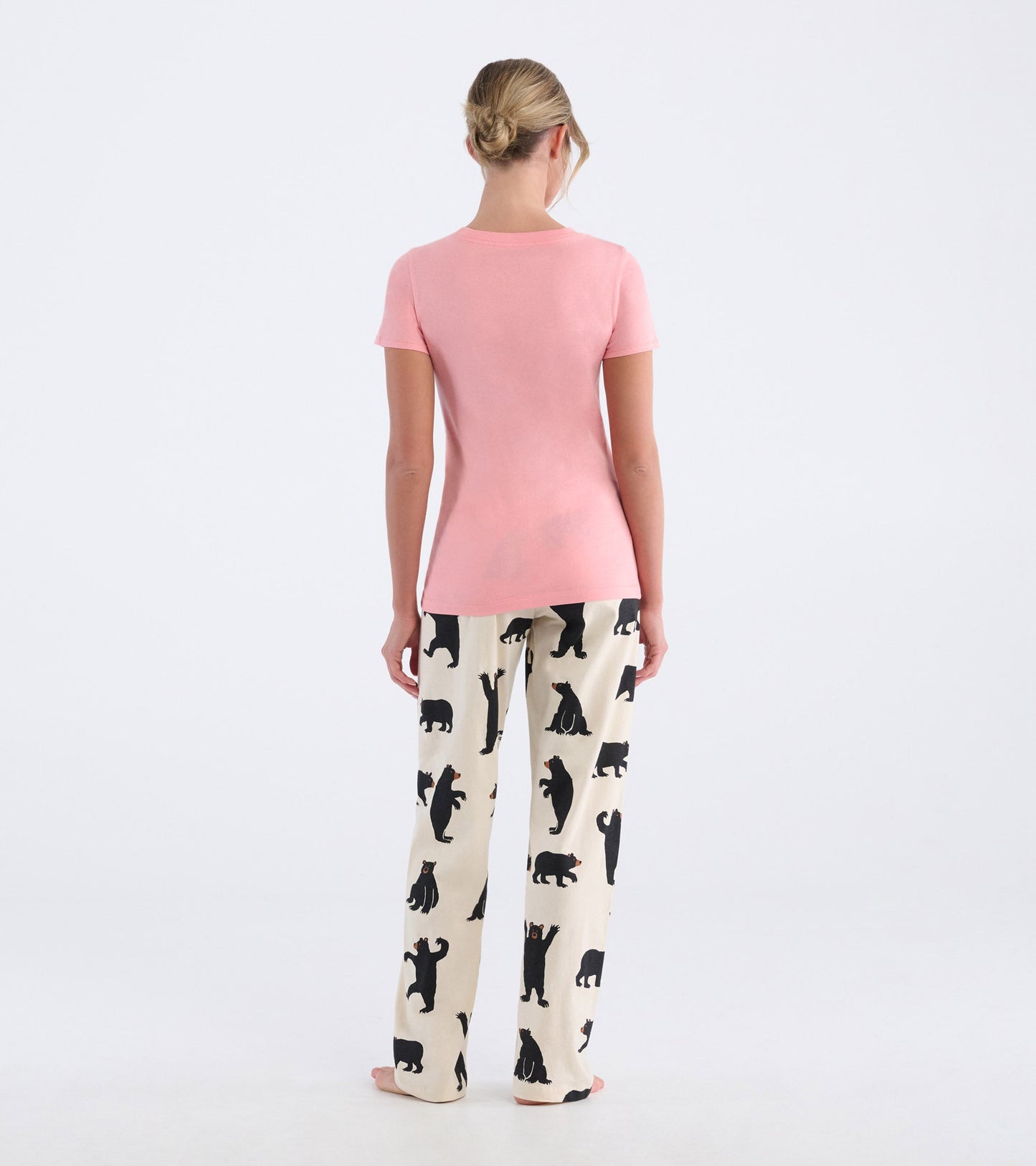 Pink short-sleeve pajama t-shirt paired with cream pants featuring black bear patterns, shown from the back.