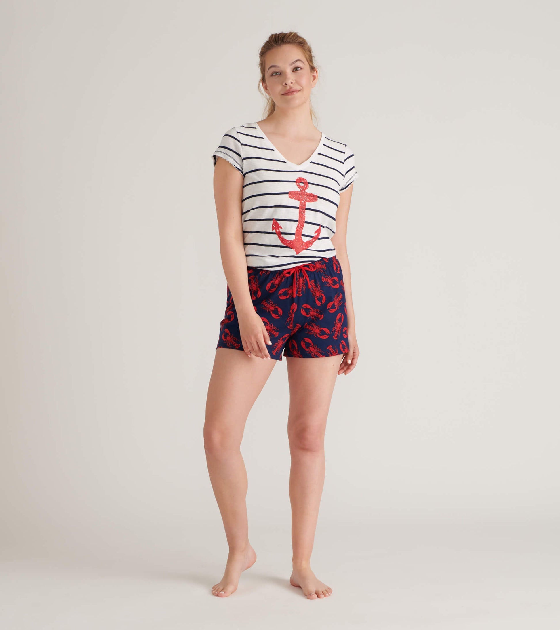 White striped V-neck tee with a red anchor graphic, paired with navy shorts featuring a lobster pattern.