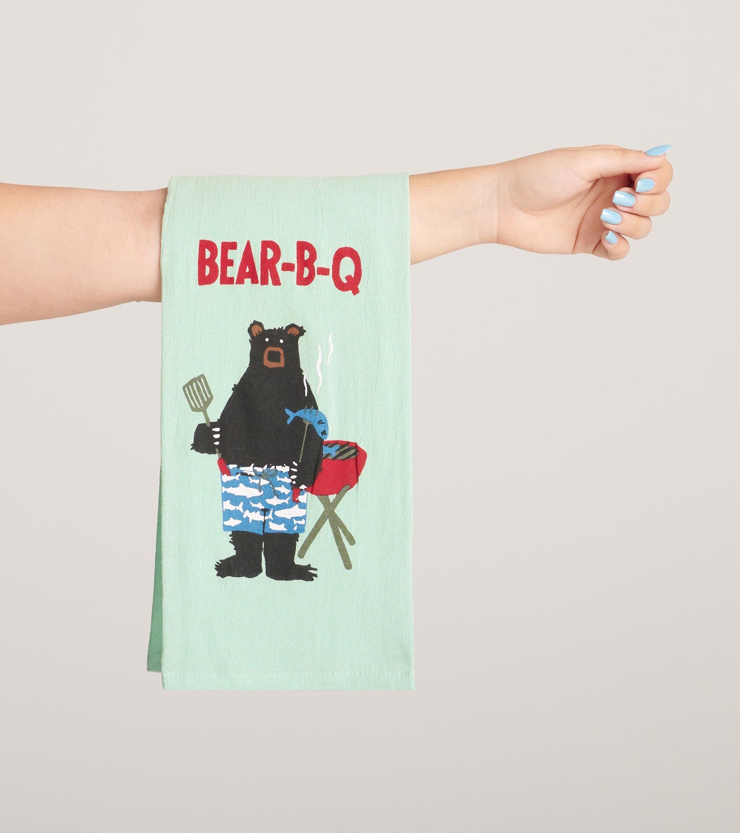 Light green tea towel featuring a bear grilling, with "BEAR-B-Q" text and colorful shorts pattern.