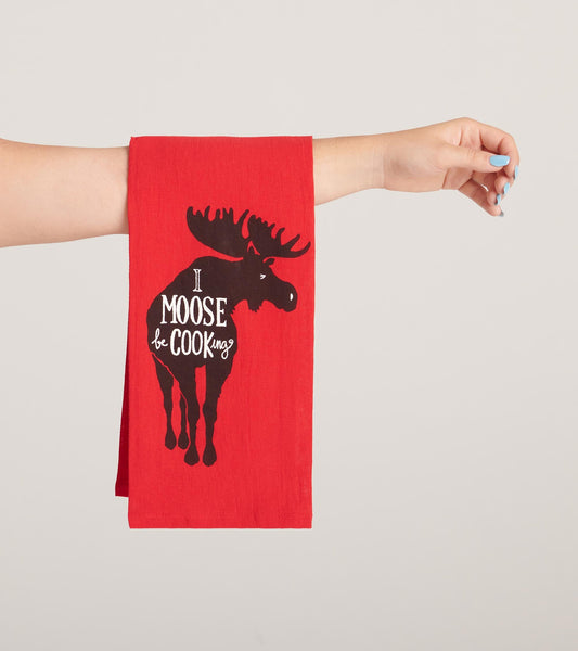 Red tea towel featuring a black moose graphic and the text "I Moose Be Cooking.