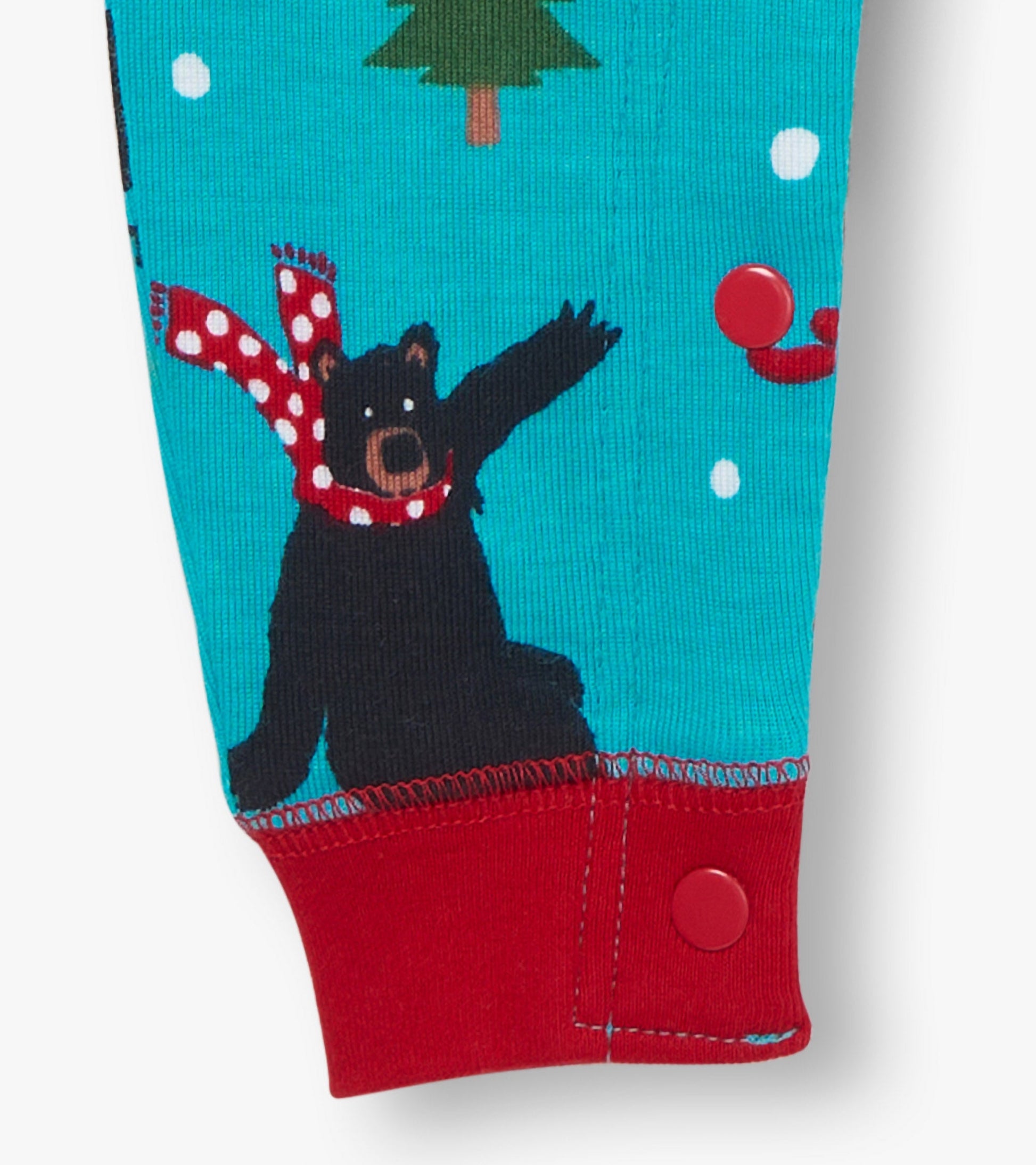 Turquoise union suit featuring a black bear in a red scarf, with snowflakes and a tree pattern, and red snap closures.