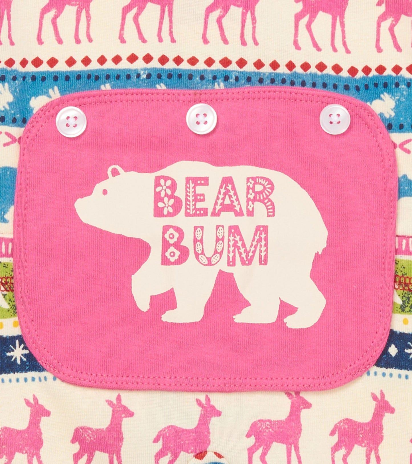 Pink bear-themed patch on a cream union suit featuring colorful Fair Isle patterns with deer and snowflakes.